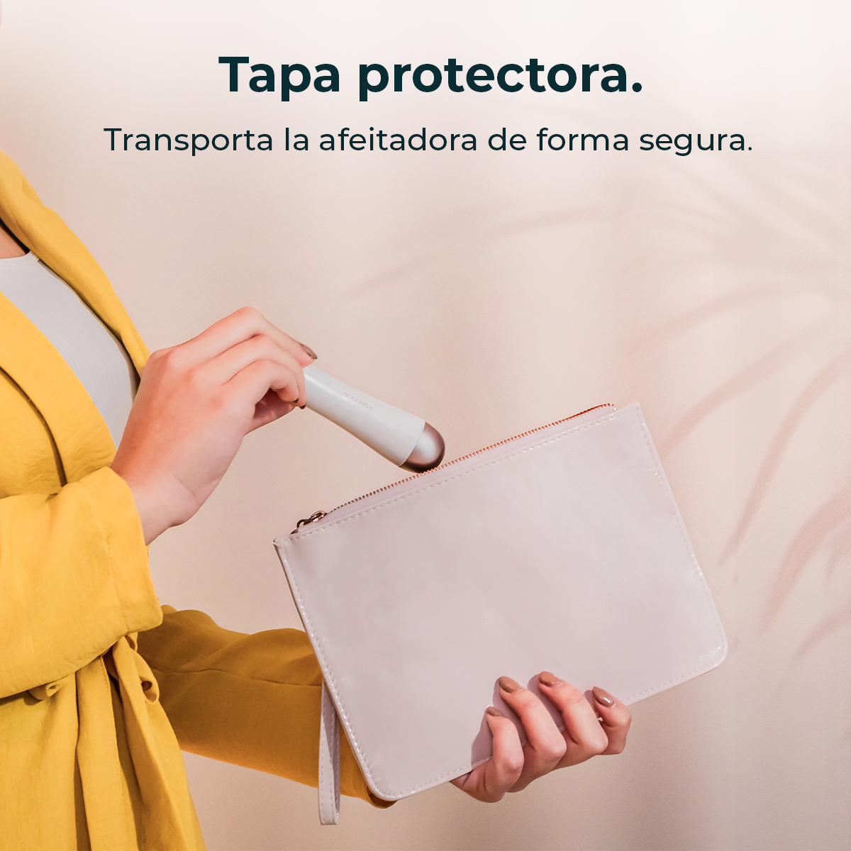 Una persona con chaqueta amarilla guarda una afeitadora en un estuche rosa sobre fondo neutro.