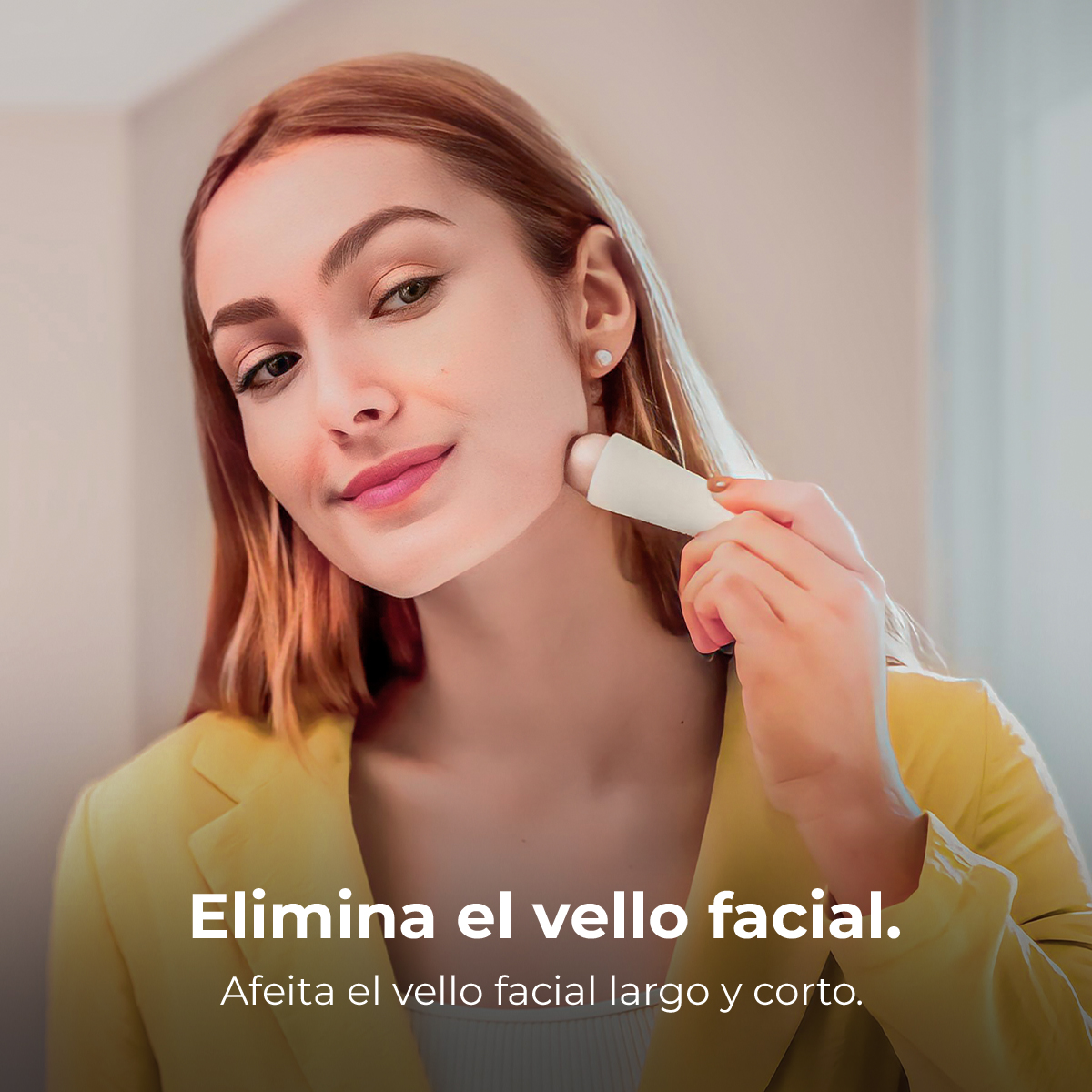 Una mujer con blazer amarillo usa un pequeño depilador facial blanco en su mejilla.