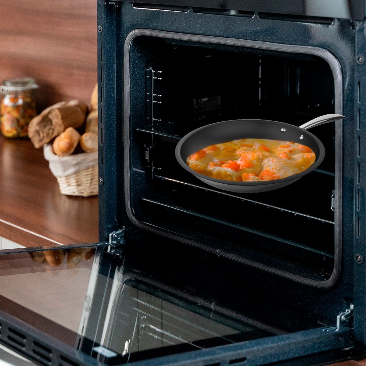 Una sartén con cazuela en la rejilla del horno, con cestas de pan y frascos.
