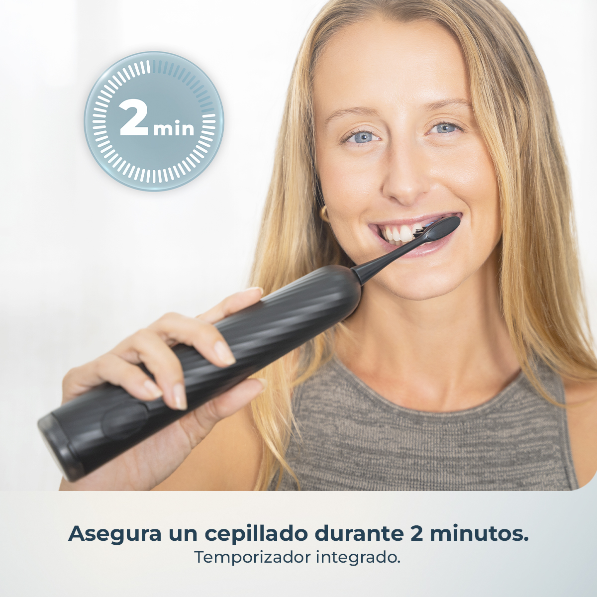 Una mujer sonriente se cepilla los dientes con un cepillo eléctrico negro junto a un icono de temporizador de 2 minutos.