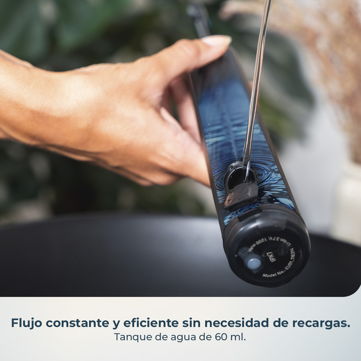 Una mano sostiene un dispositivo elegante con diseño azul mientras se vierte agua en su válvula abierta.