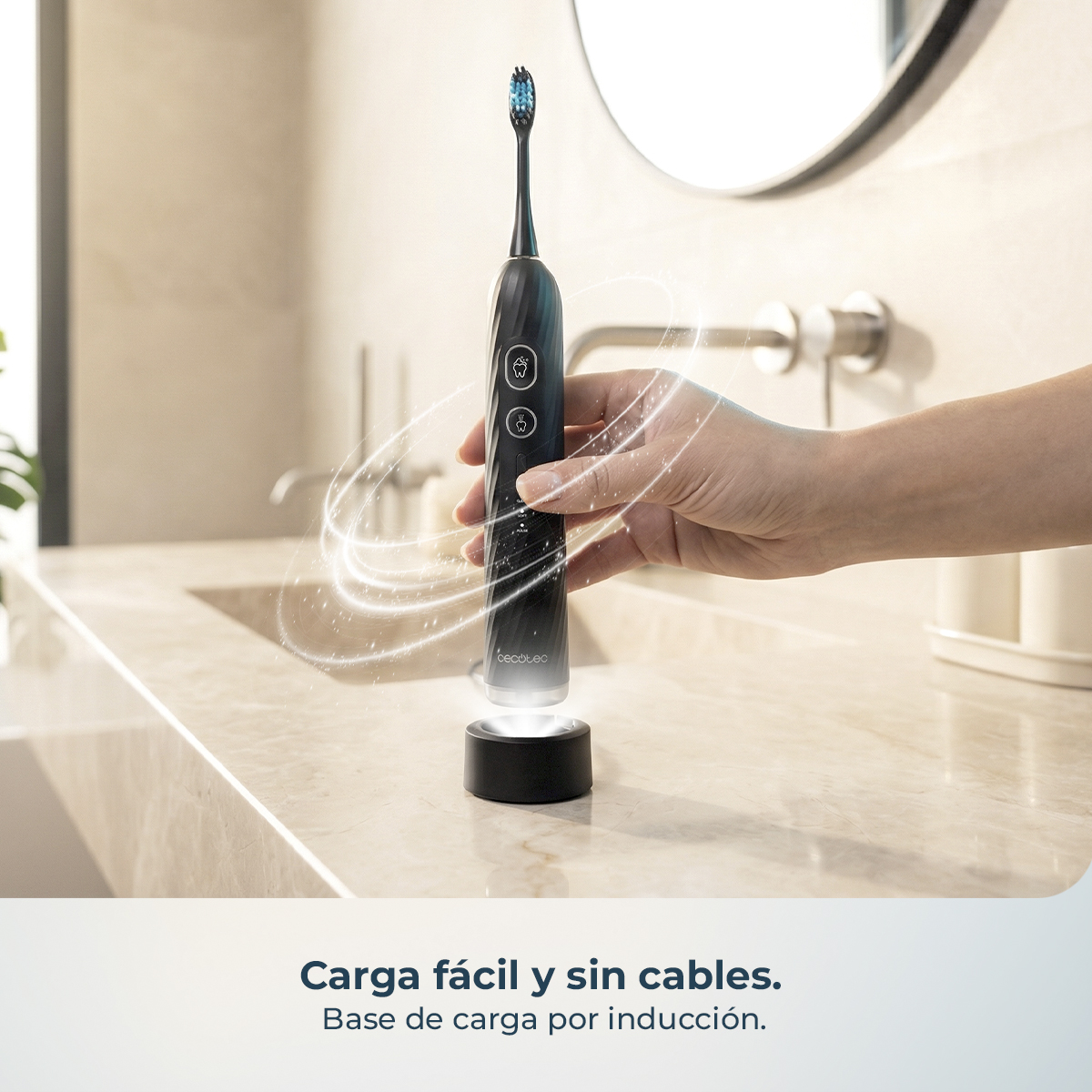 Mano sostiene un cepillo eléctrico negro sobre una base de carga por inducción en un lavabo.