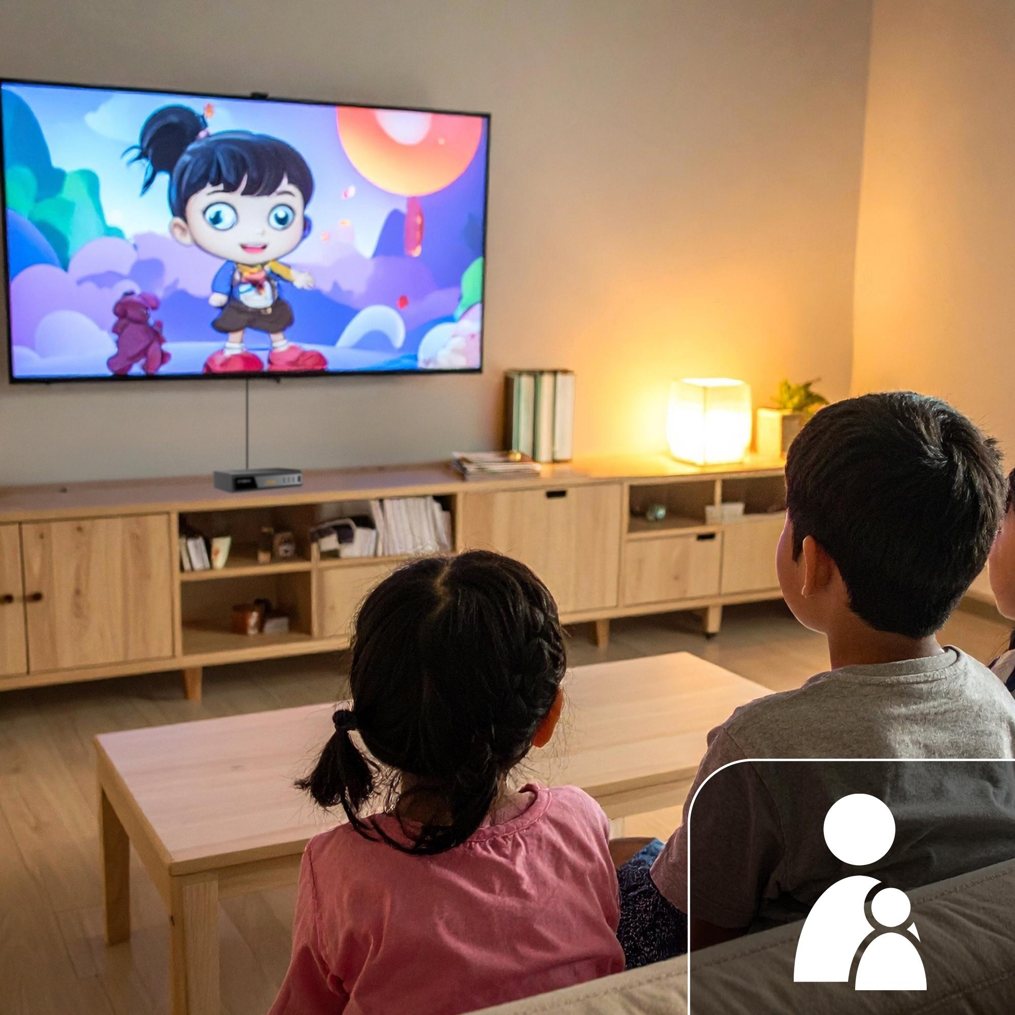 Zwei Kinder sitzen auf einem Sofa und schauen einen bunten Zeichentrickfilm im Fernsehen an.