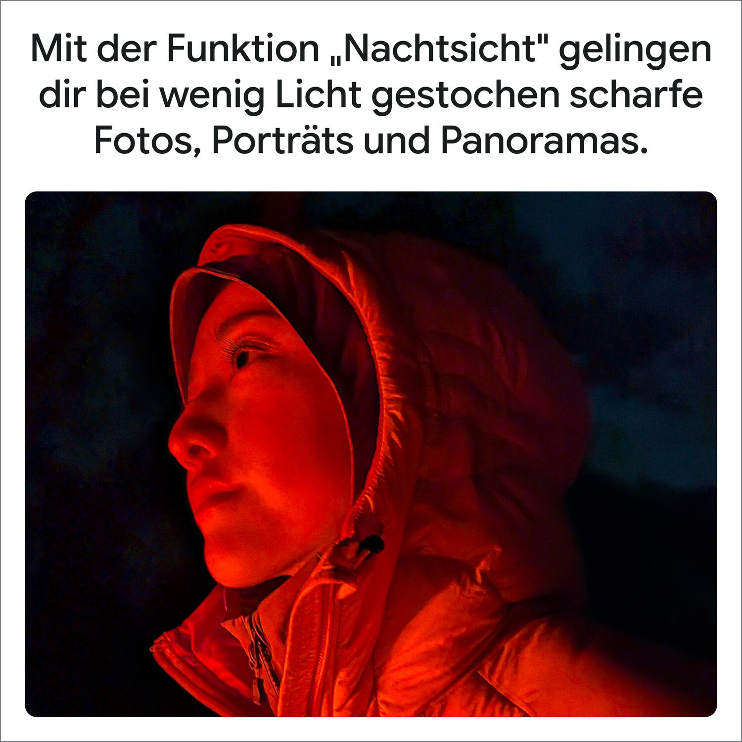 Eine Person im roten Kapuzenpulli schaut im dunkeln nach oben, beleuchtet von warmem rotem Licht.