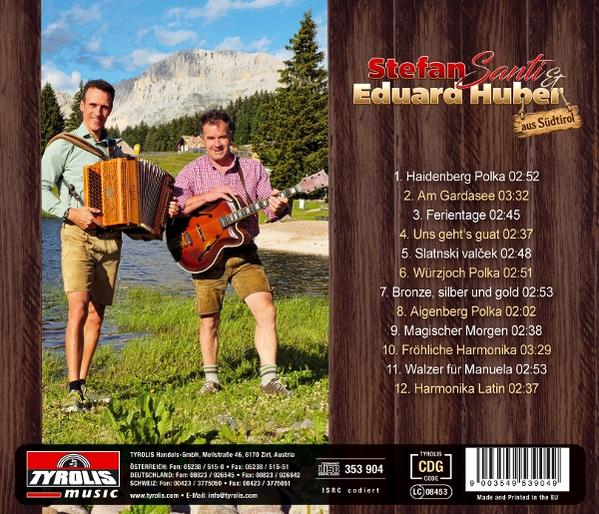 Zwei traditionell gekleidete Musiker posieren vor einer Bergkulisse am See; rechts befindet sich die Titelliste.