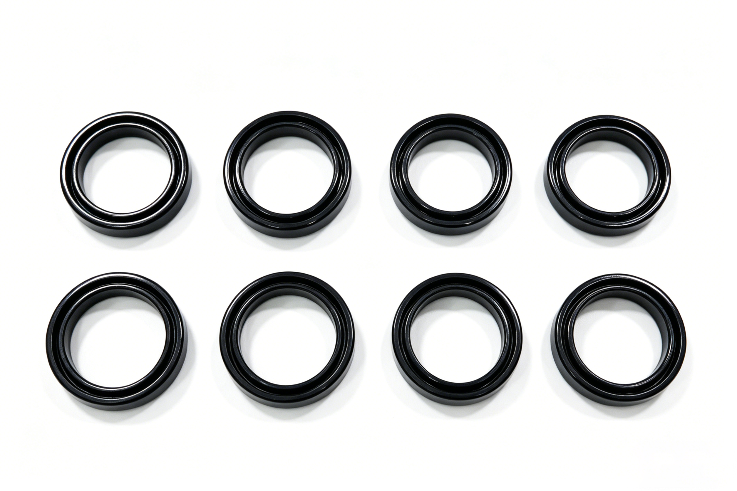 Huit joints ou anneaux circulaires noirs disposés en deux rangées sur fond blanc.