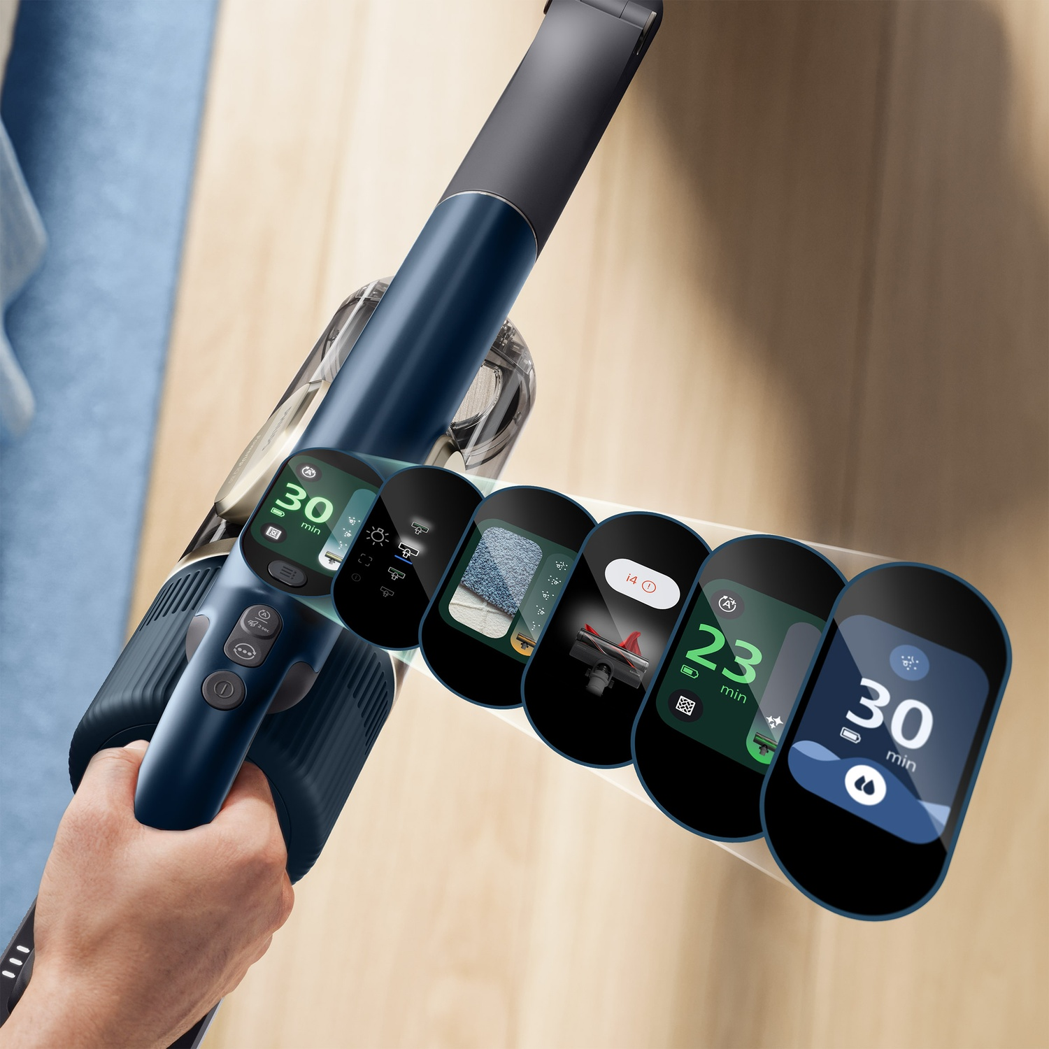 A hand holds a blue cordless vacuum with a digital display showing various operating modes and battery runtimes.