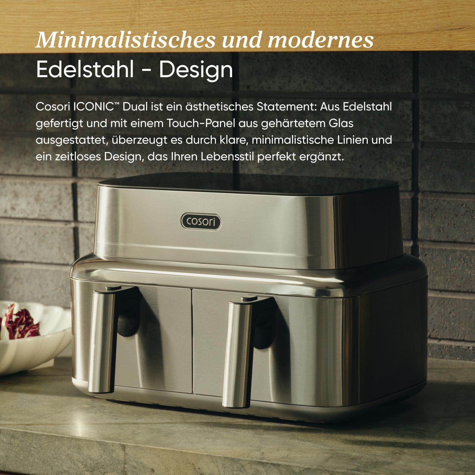 Moderne Cosori Heißluftfritteuse aus Edelstahl mit zwei Schubladen auf einer Küchenarbeitsplatte.