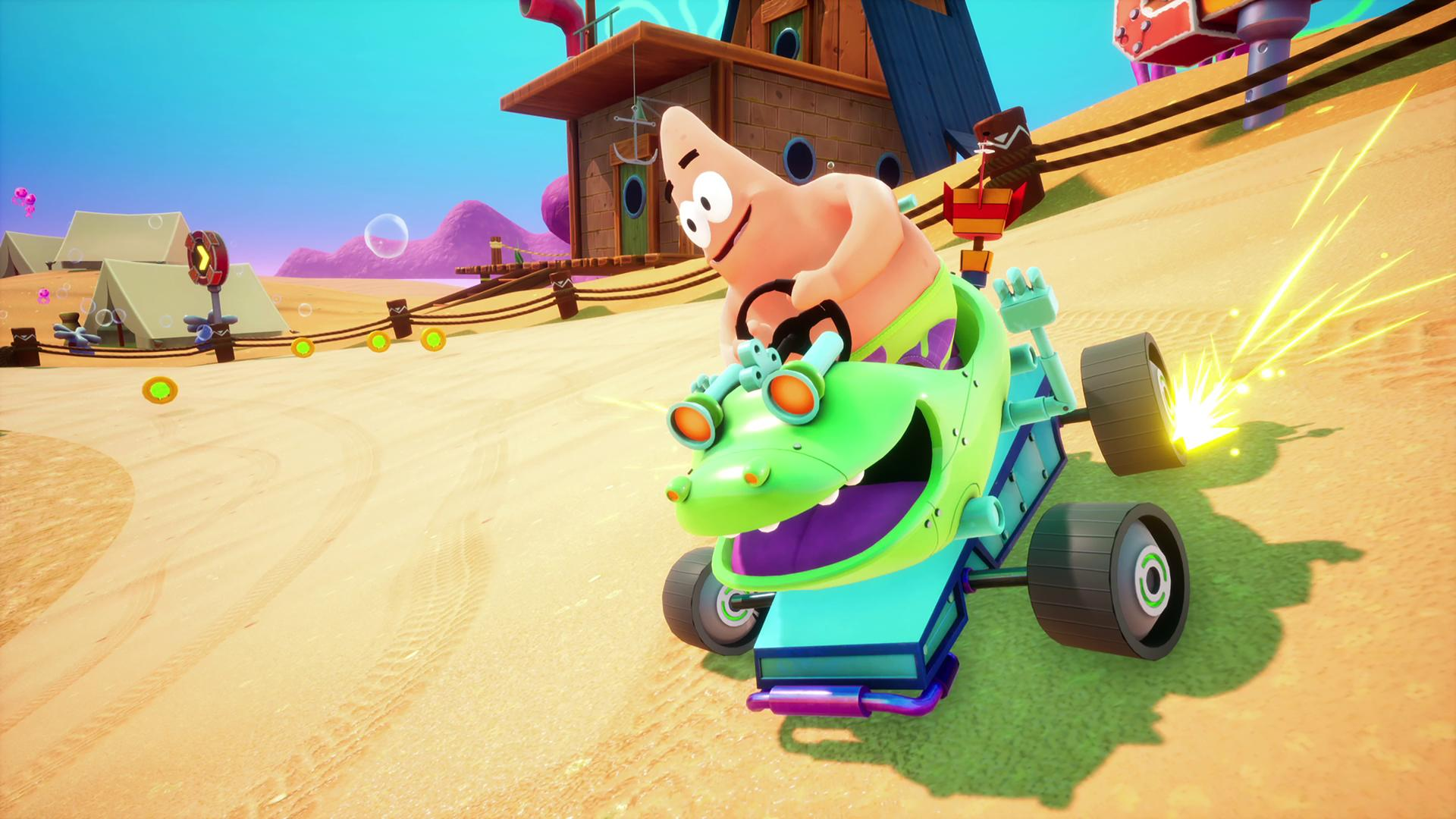 Patrick Stella guida un kart verde a forma di coccodrillo su una pista sabbiosa.