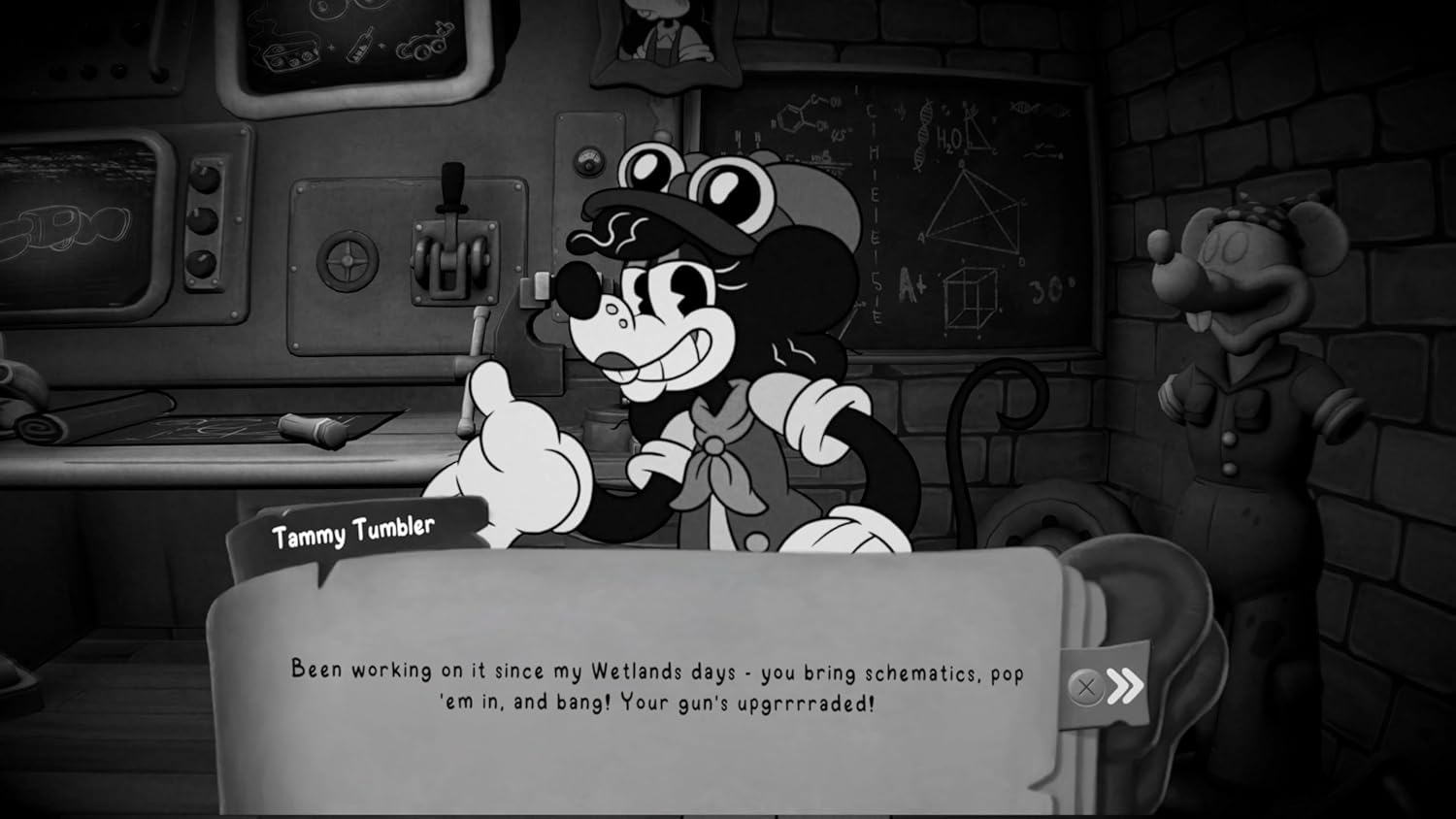 Un personnage de dessin animé nommé Tammy Tumbler parle dans un atelier devant un tableau noir et des machines.