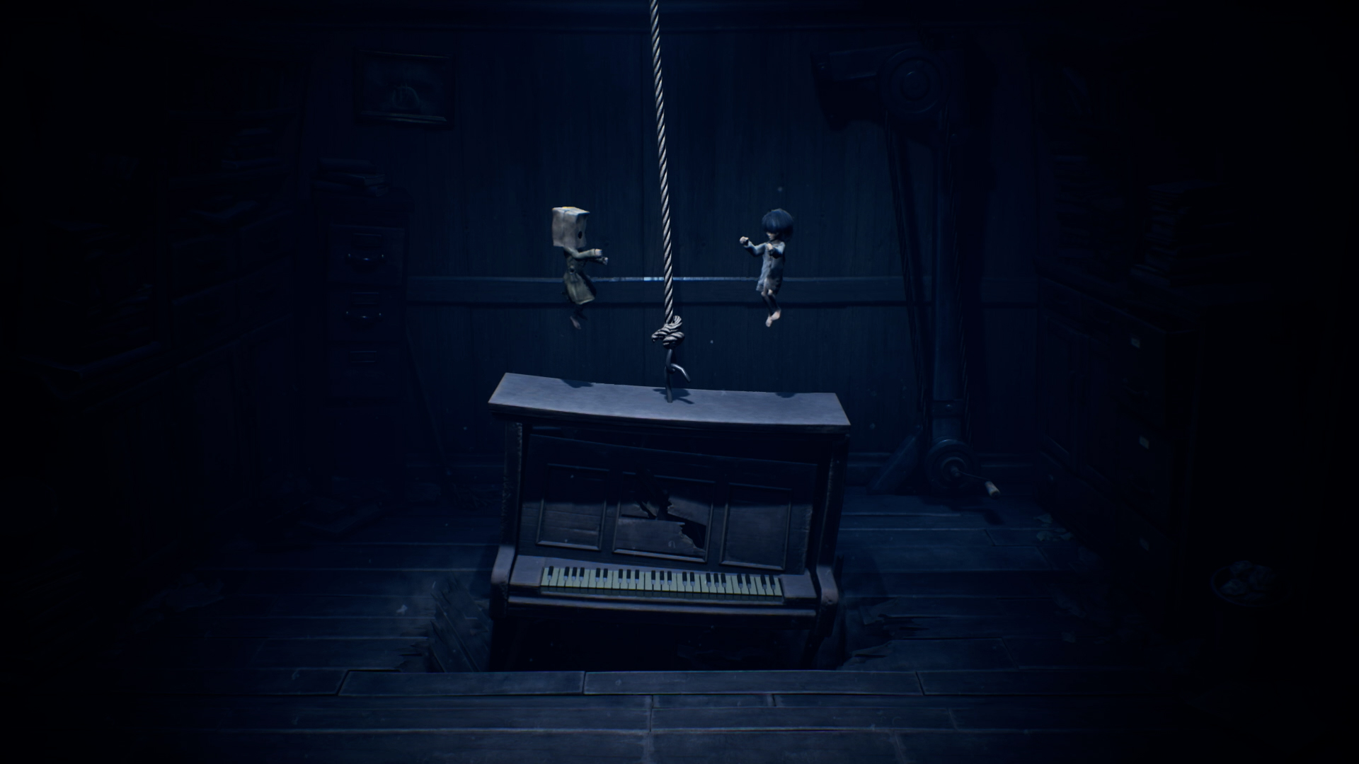 Deux petites silhouettes flottent au-dessus d'un piano suspendu dans une pièce sombre.