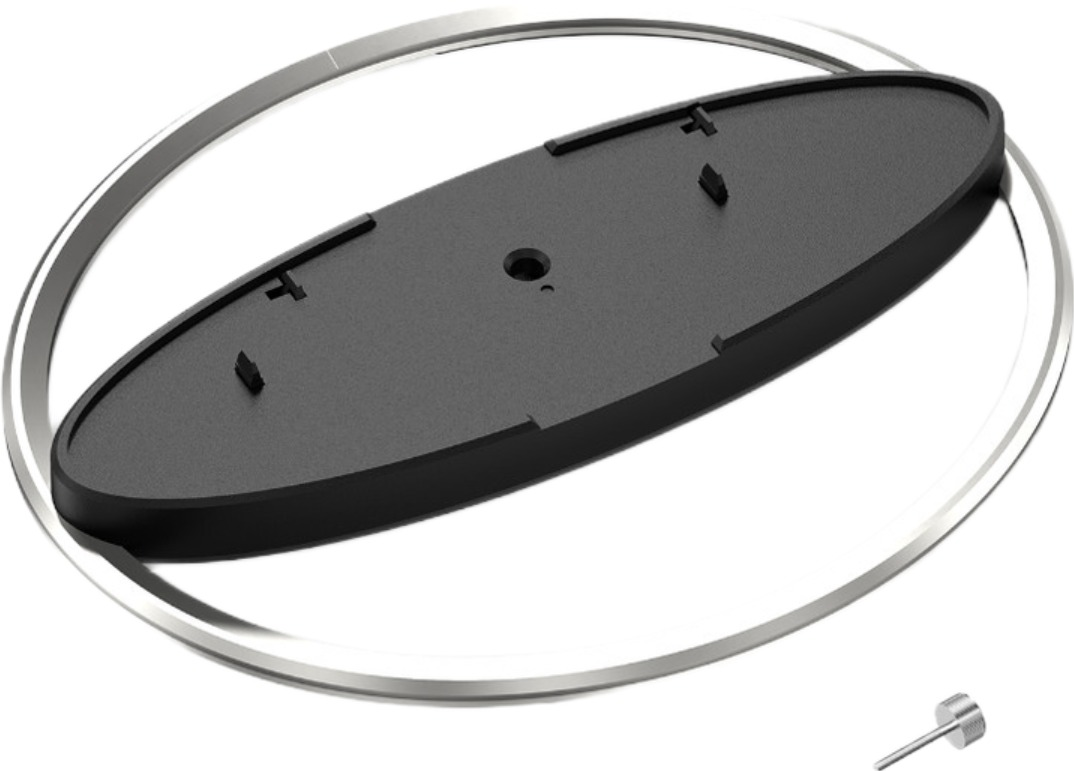 Srebrny metalowy pierścień z czarną owalną plastikową płytką i małą śrubką w prawym dolnym rogu.