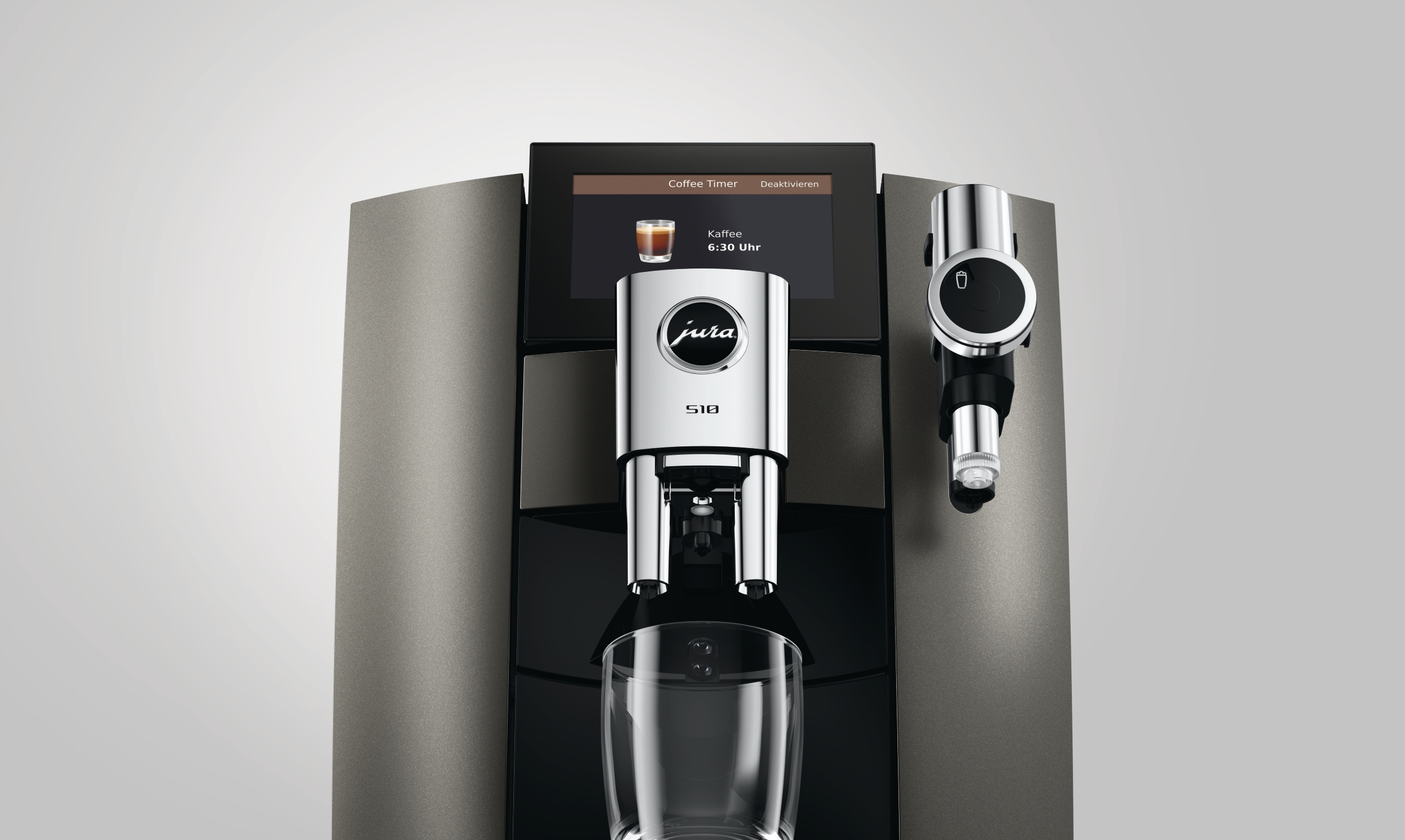 Moderne Jura S10 Kaffeemaschine in Grau mit Digitaldisplay und Glasbecher.