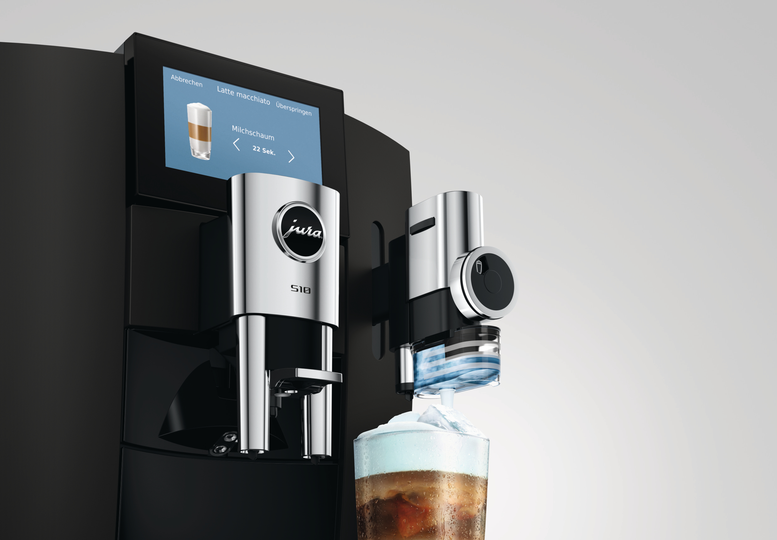 Moderne schwarze Jura S10 Kaffeemaschine mit Display bereitet einen Latte Macchiato in einem Glas zu.
