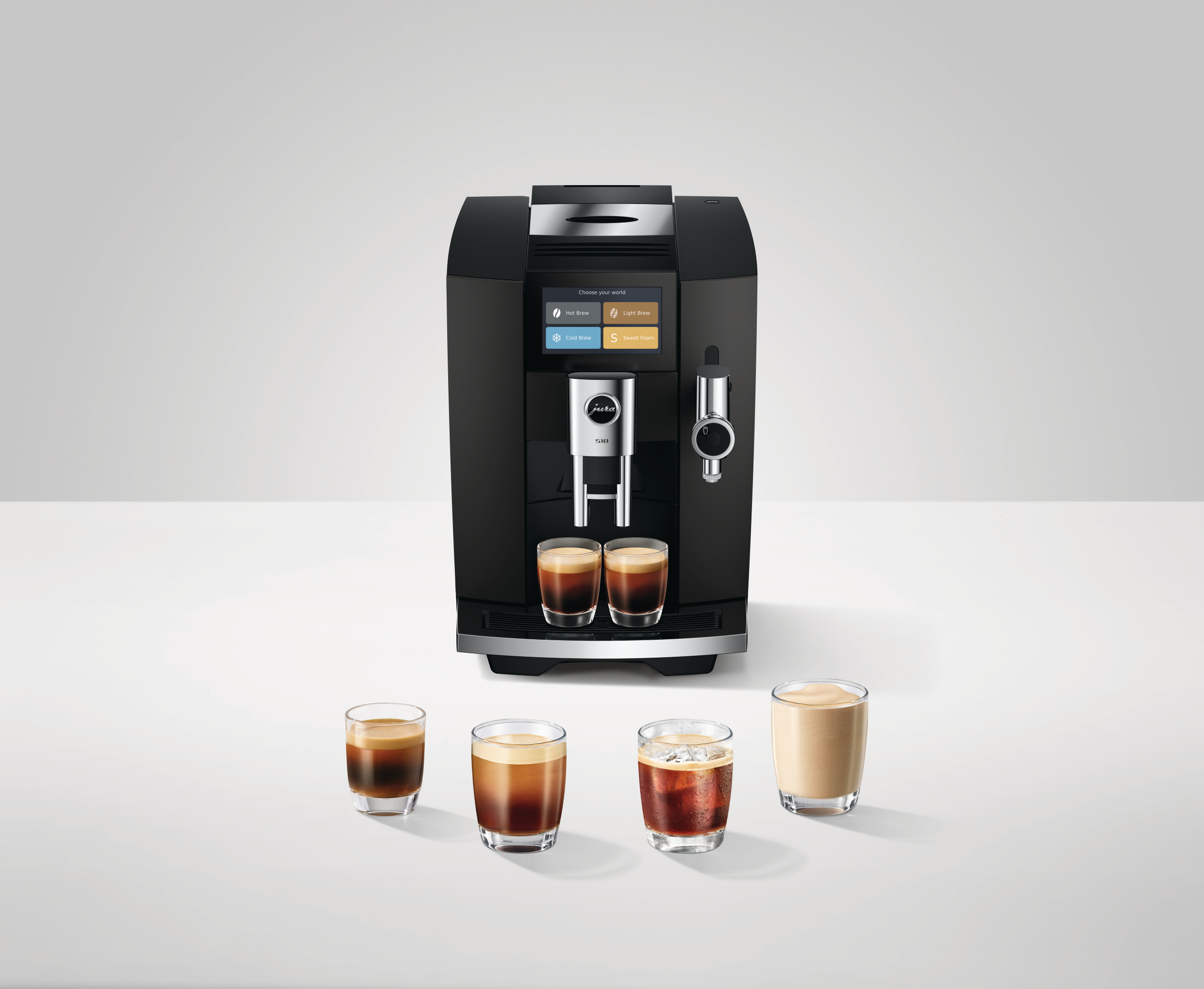 Eine schwarze Jura S10 Kaffeemaschine steht auf einer weißen Oberfläche mit vier Gläsern mit verschiedenen Kaffeespezialitäten.