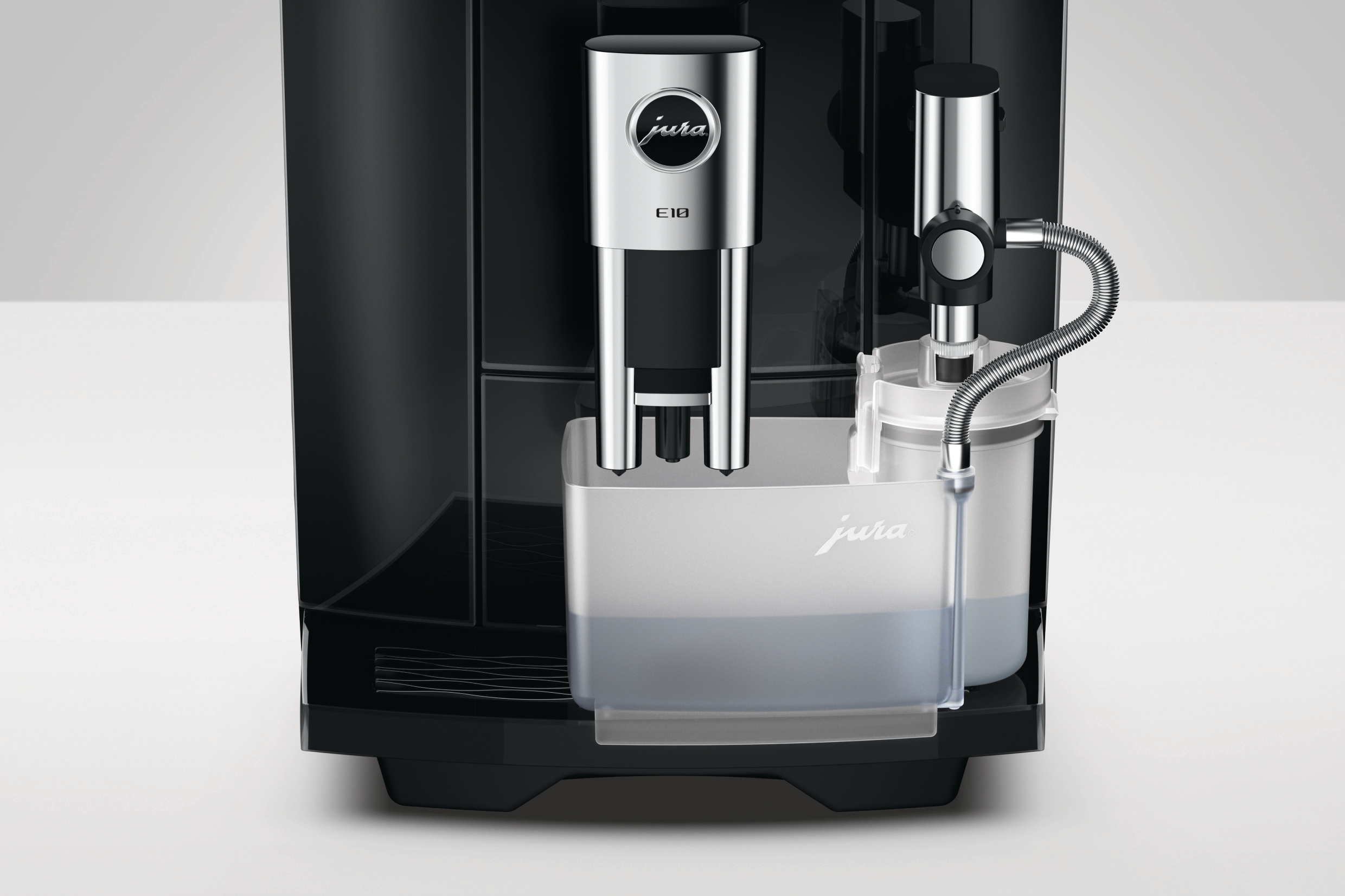 Schwarze Jura E10 Kaffeemaschine mit integriertem Milchbehälter und verchromtem Spender vor hellem Hintergrund.
