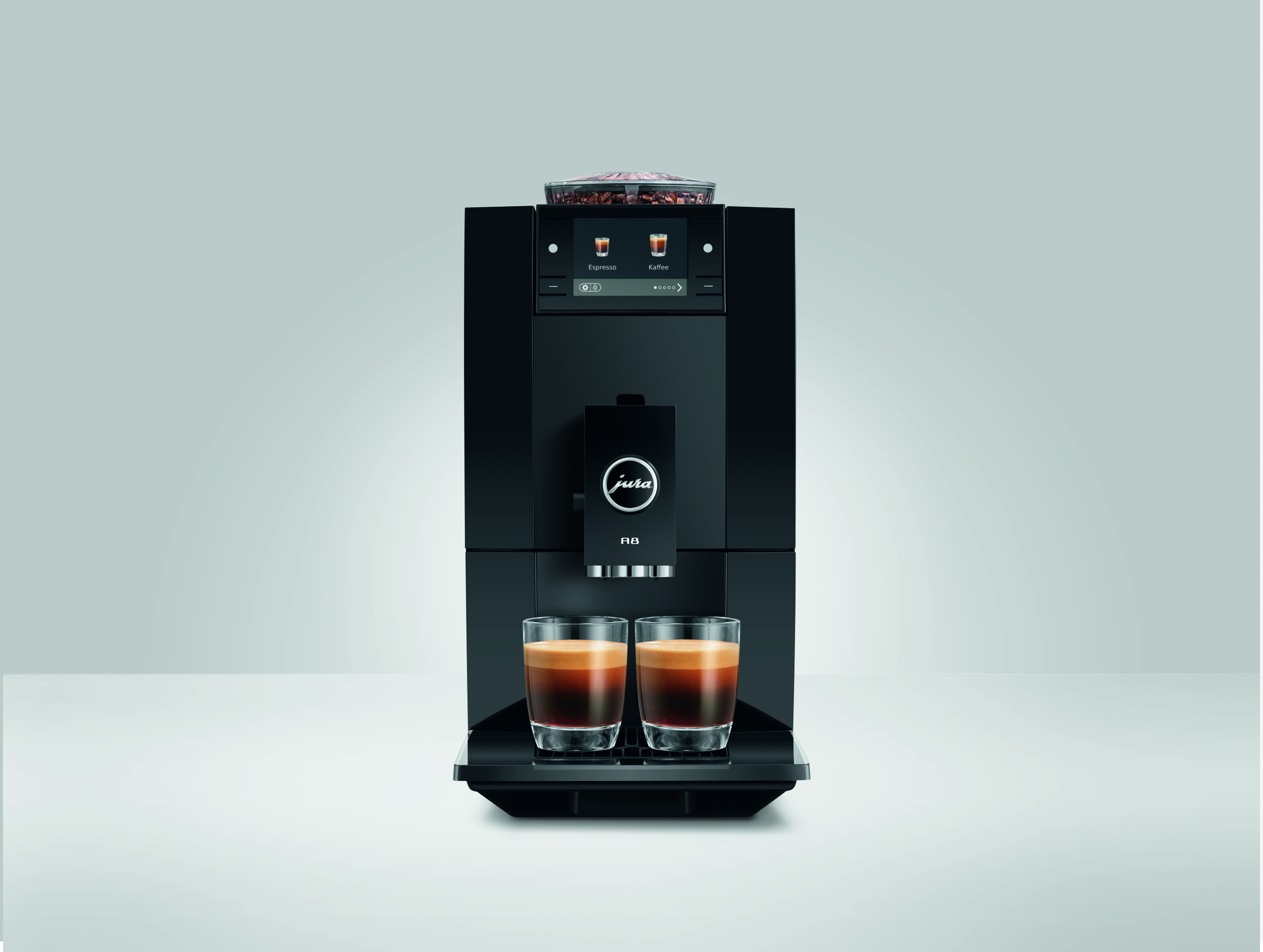 Schwarzer Jura A8 Kaffeevollautomat auf hellem Hintergrund mit zwei Glasbechern Espresso.