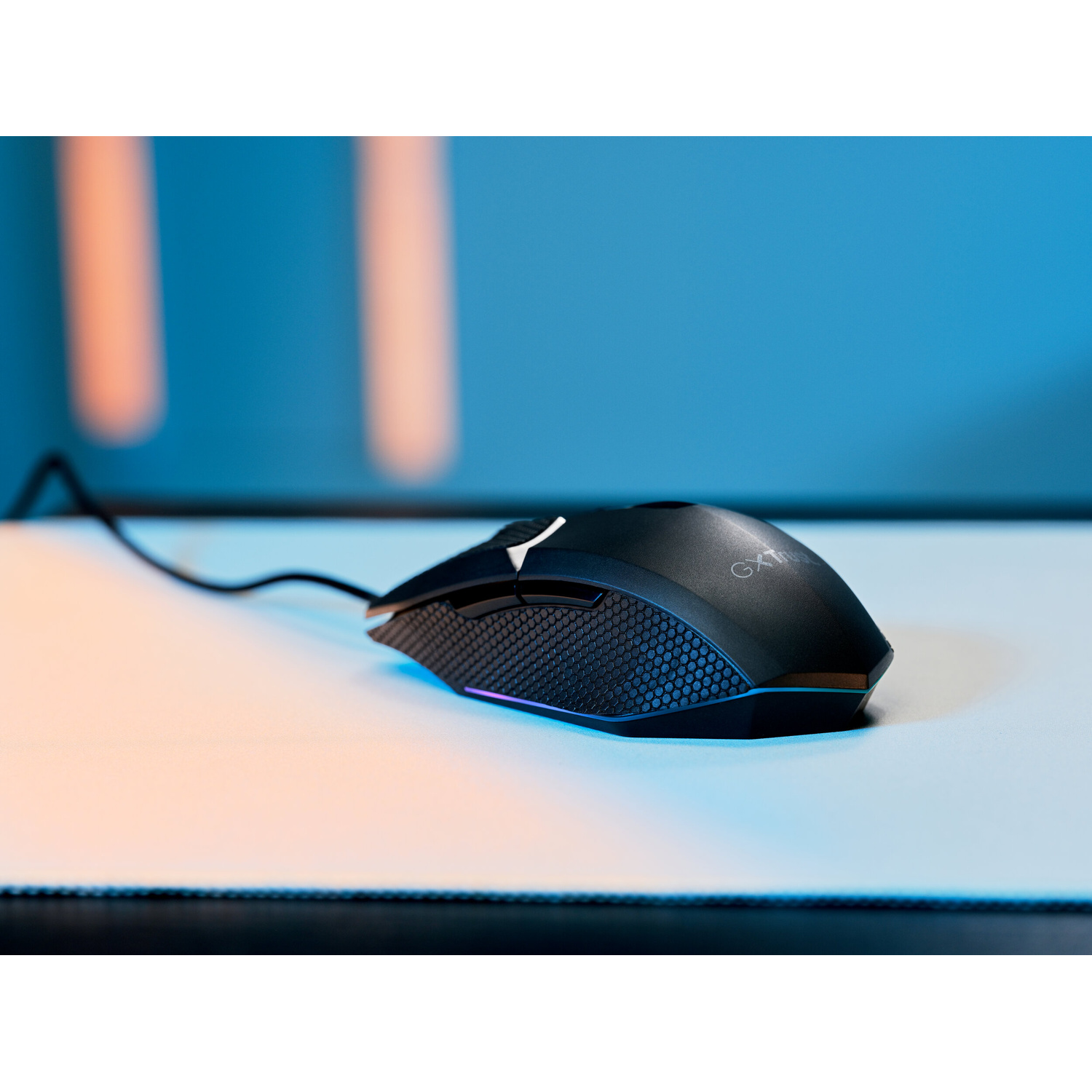 Un mouse da gioco nero con impugnatura testurizzata e illuminazione RGB su un tappetino chiaro con sfondo blu.