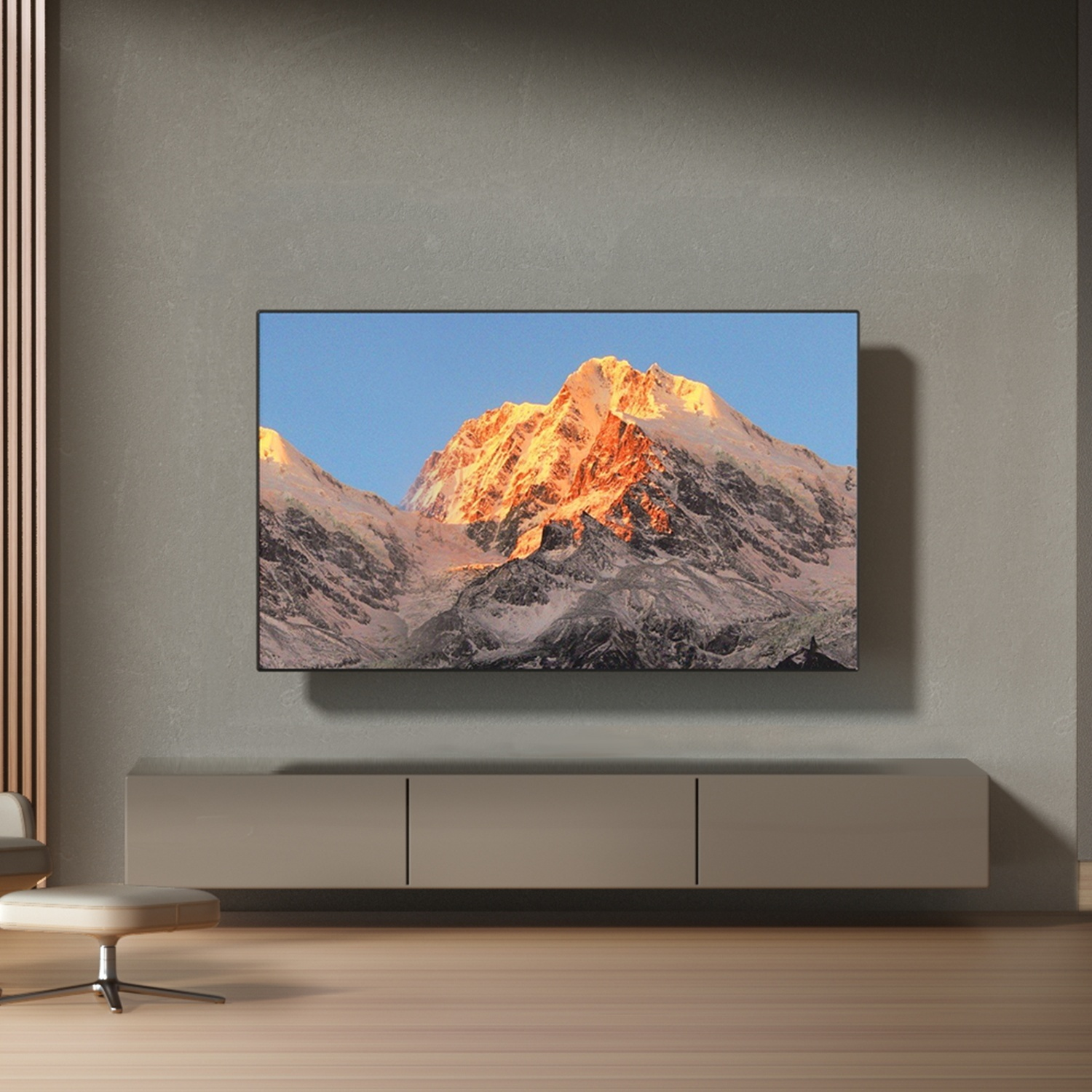 Una TV a schermo piatto mostra montagne innevate su una parete grigia sopra una credenza.
