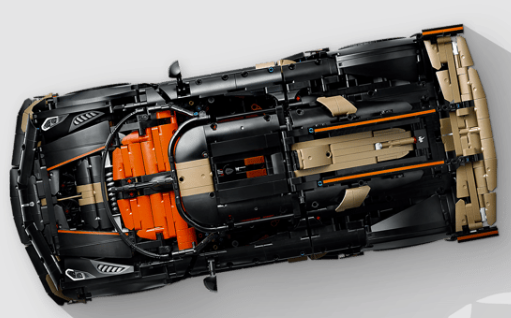 Ansicht von oben eines schwarz-orangen Spielzeugauto-Modells auf hellem Hintergrund.