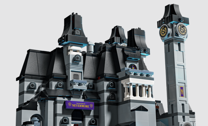 Detailaufnahme eines grauen LEGO Nevermore-Schlosses mit schwarzem Dach und einem hohen Glockenturm auf hellem Grund.