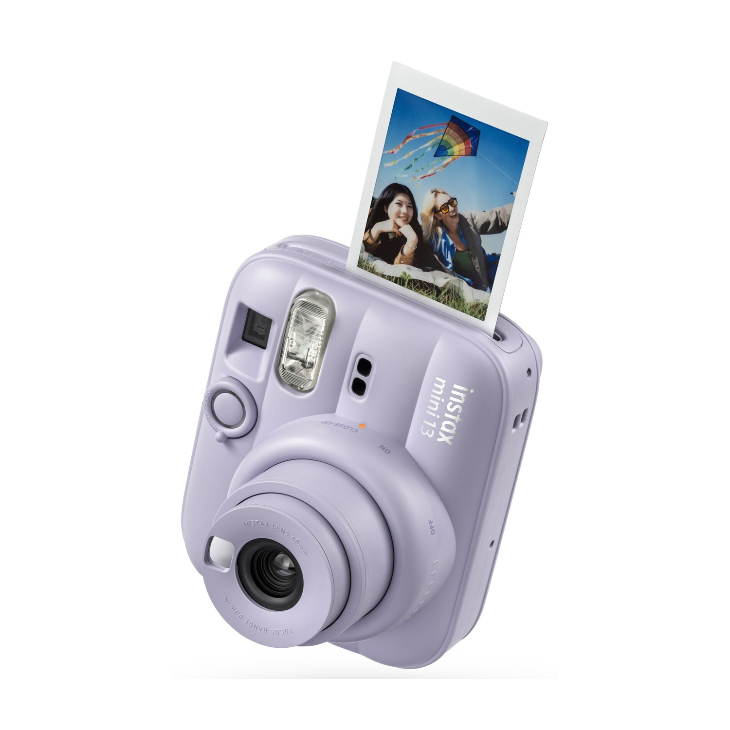 Fotocamera istantanea Instax Mini viola con una foto stampata di due donne sull'erba che esce dalla parte superiore.