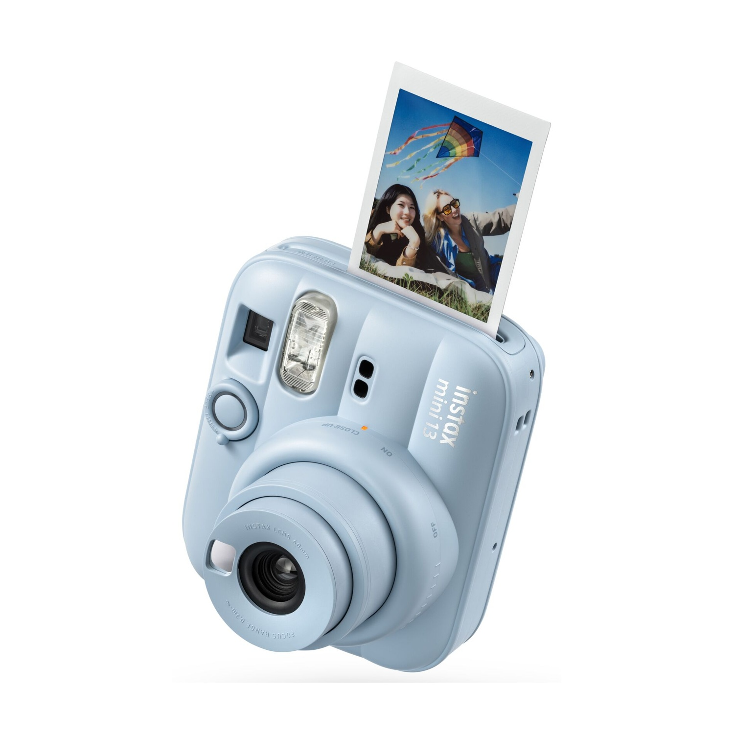 Fotocamera istantanea Instax Mini 13 azzurra con una foto espulsa che mostra due donne sorridenti e un aquilone.