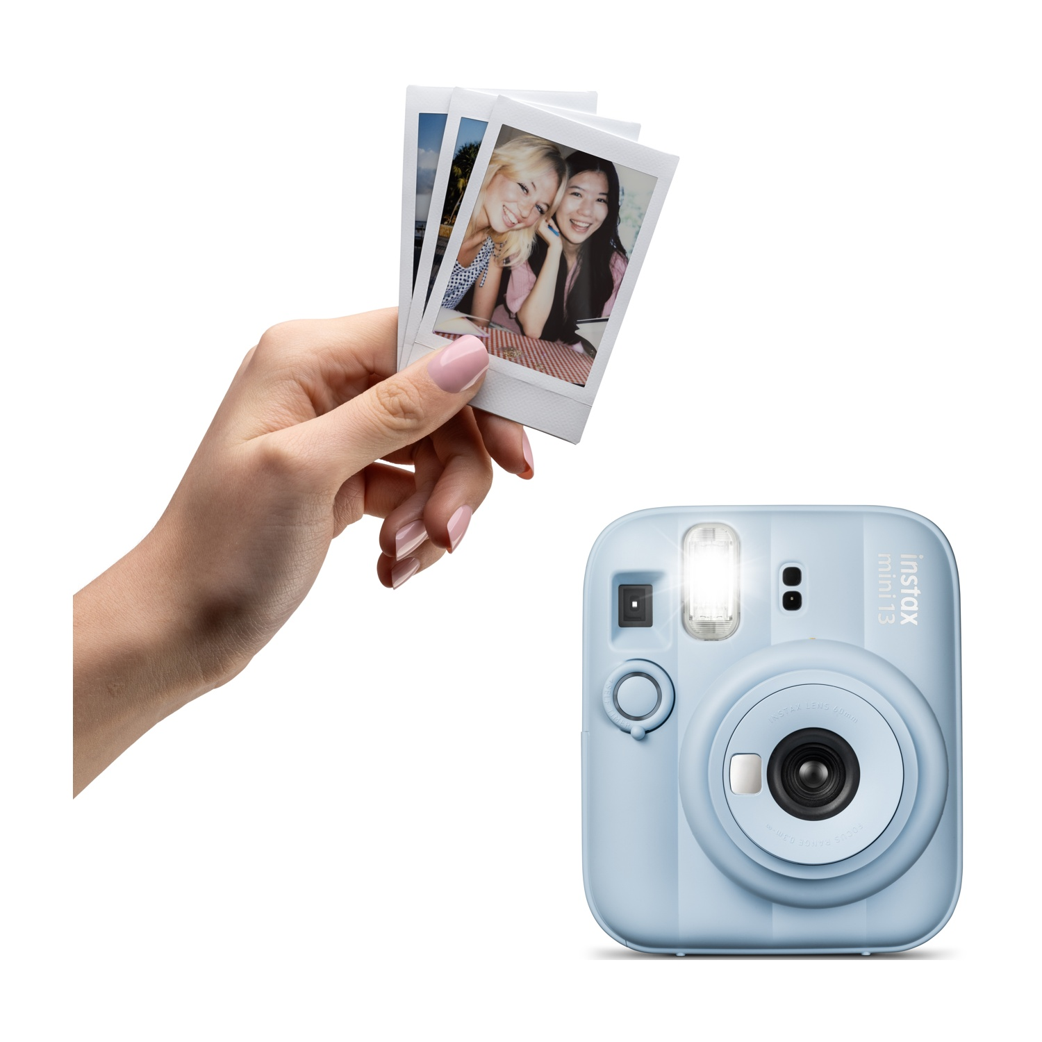 Una mano tiene tre foto istantanee accanto a una fotocamera Instax Mini azzurra.