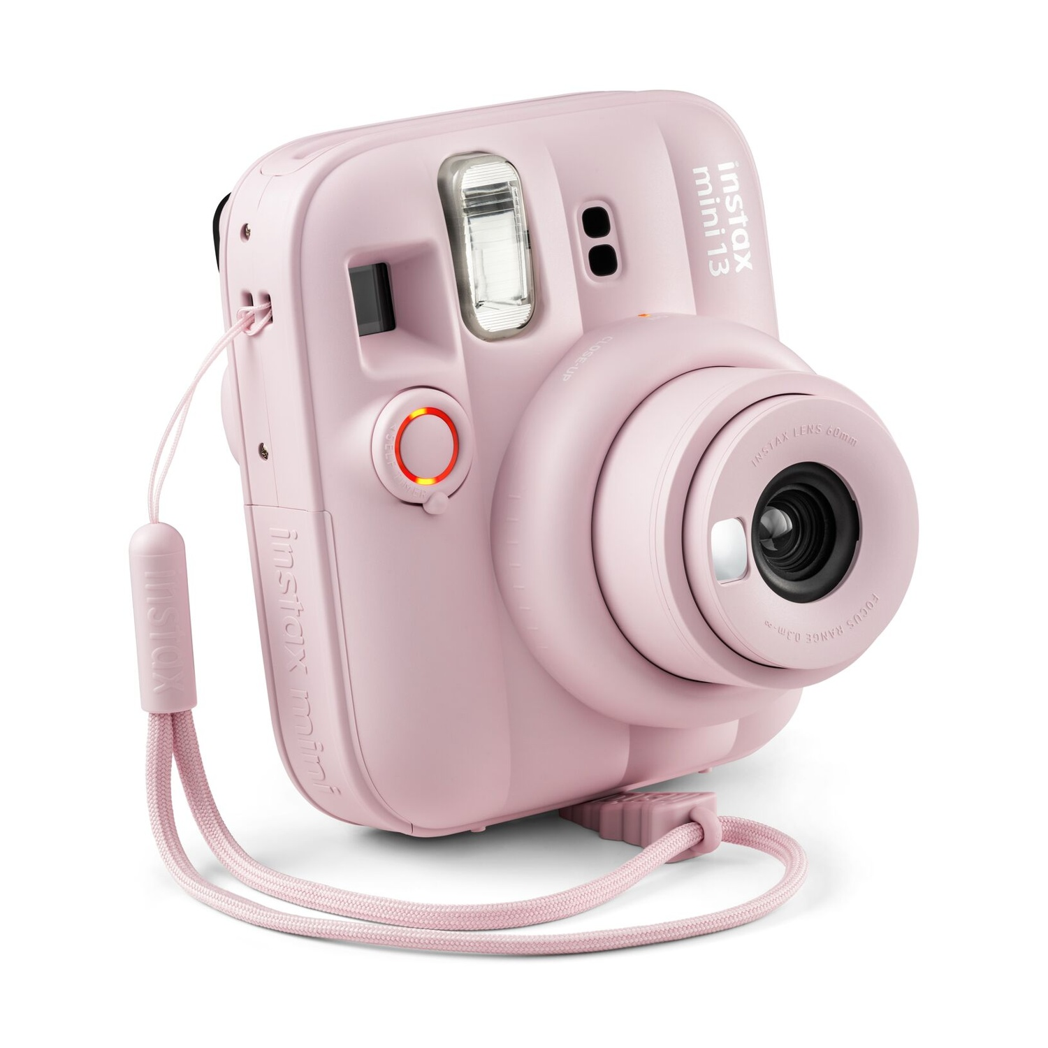 Una fotocamera istantanea Instax Mini rosa chiaro con cinturino abbinato su sfondo bianco.