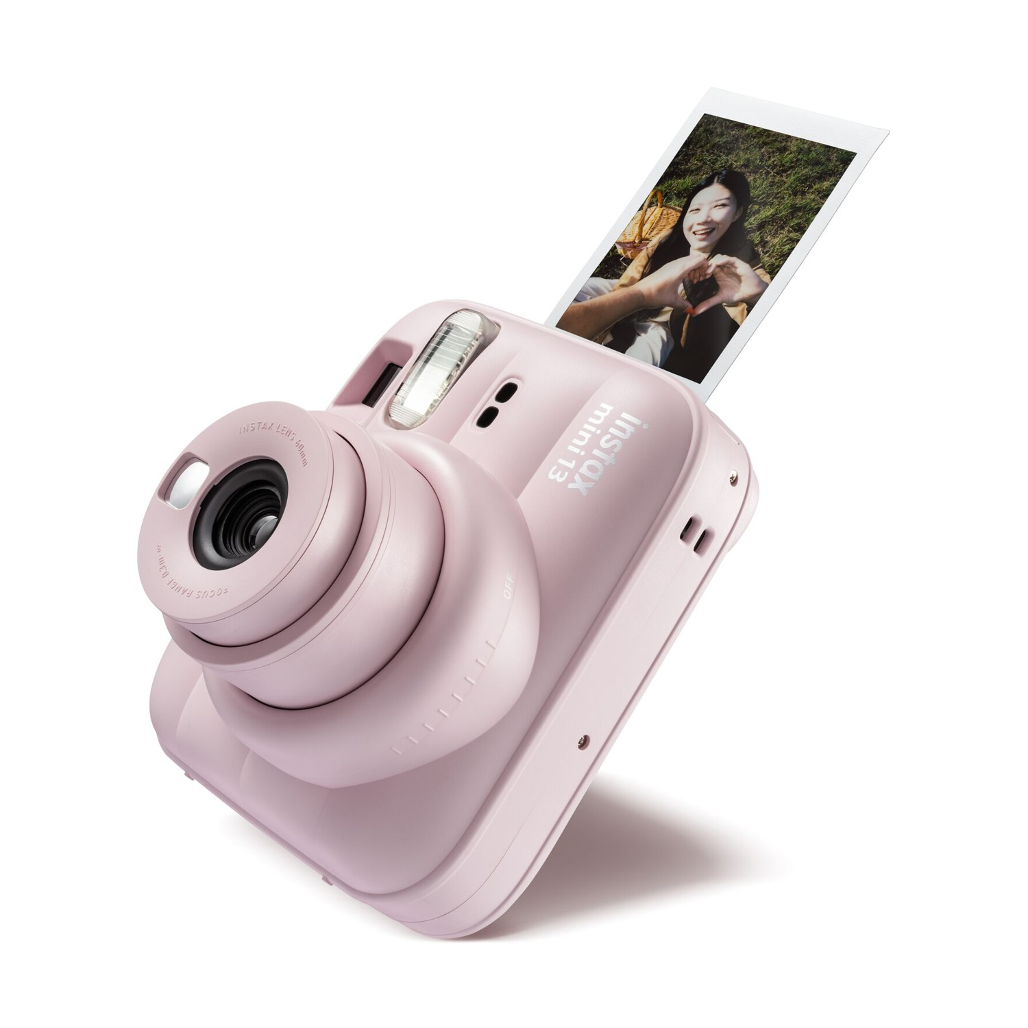 Una fotocamera istantanea Instax Mini rosa con una foto stampata di una donna sorridente.