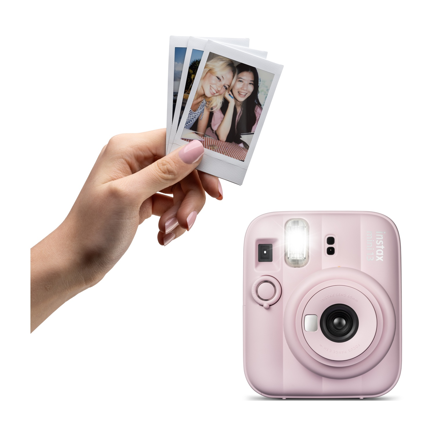 Una mano tiene tre foto istantanee davanti a una fotocamera rosa Instax Mini.