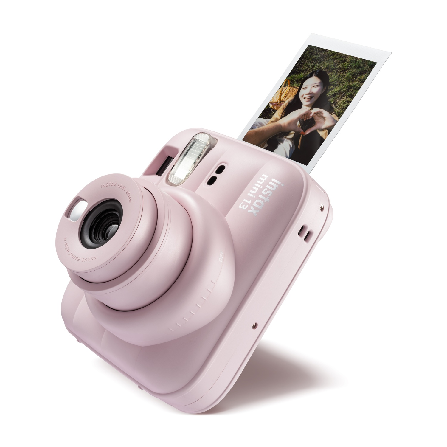 Una fotocamera istantanea Instax Mini rosa con una foto espulsa che mostra una persona sorridente.