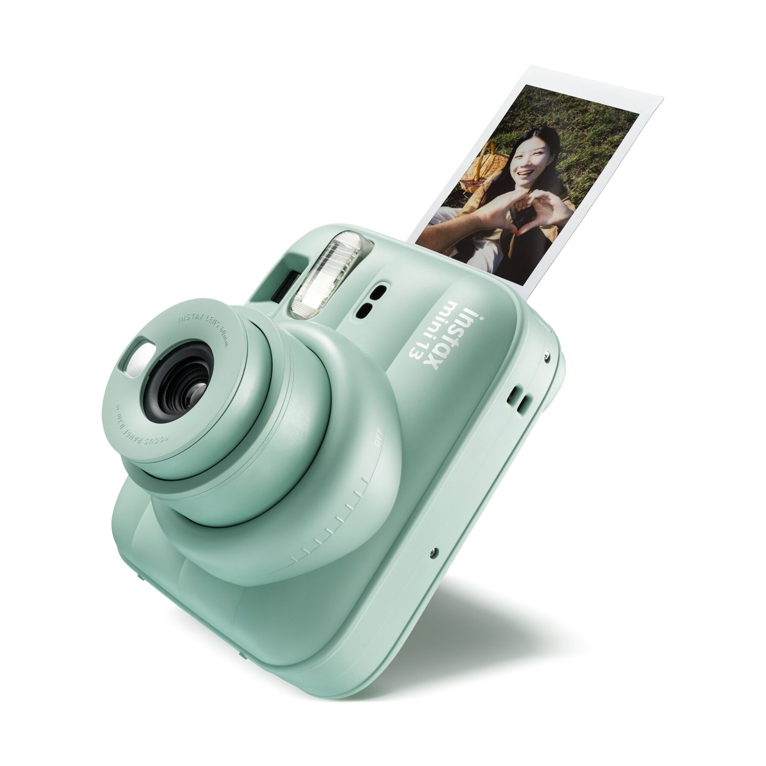 Una fotocamera istantanea Instax Mini verde menta espelle la foto di una donna sorridente.
