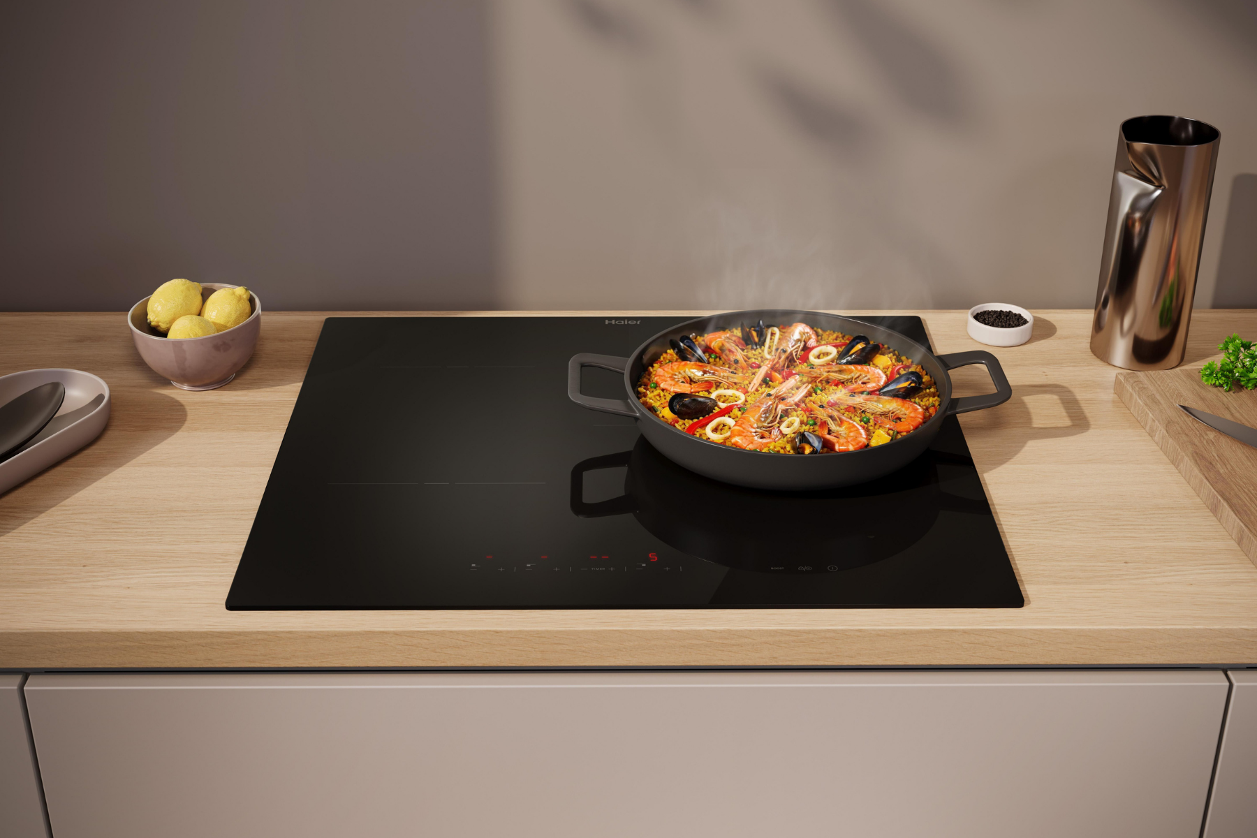 Una sartén con paella fresca se cocina en una placa de inducción negra en una cocina moderna.