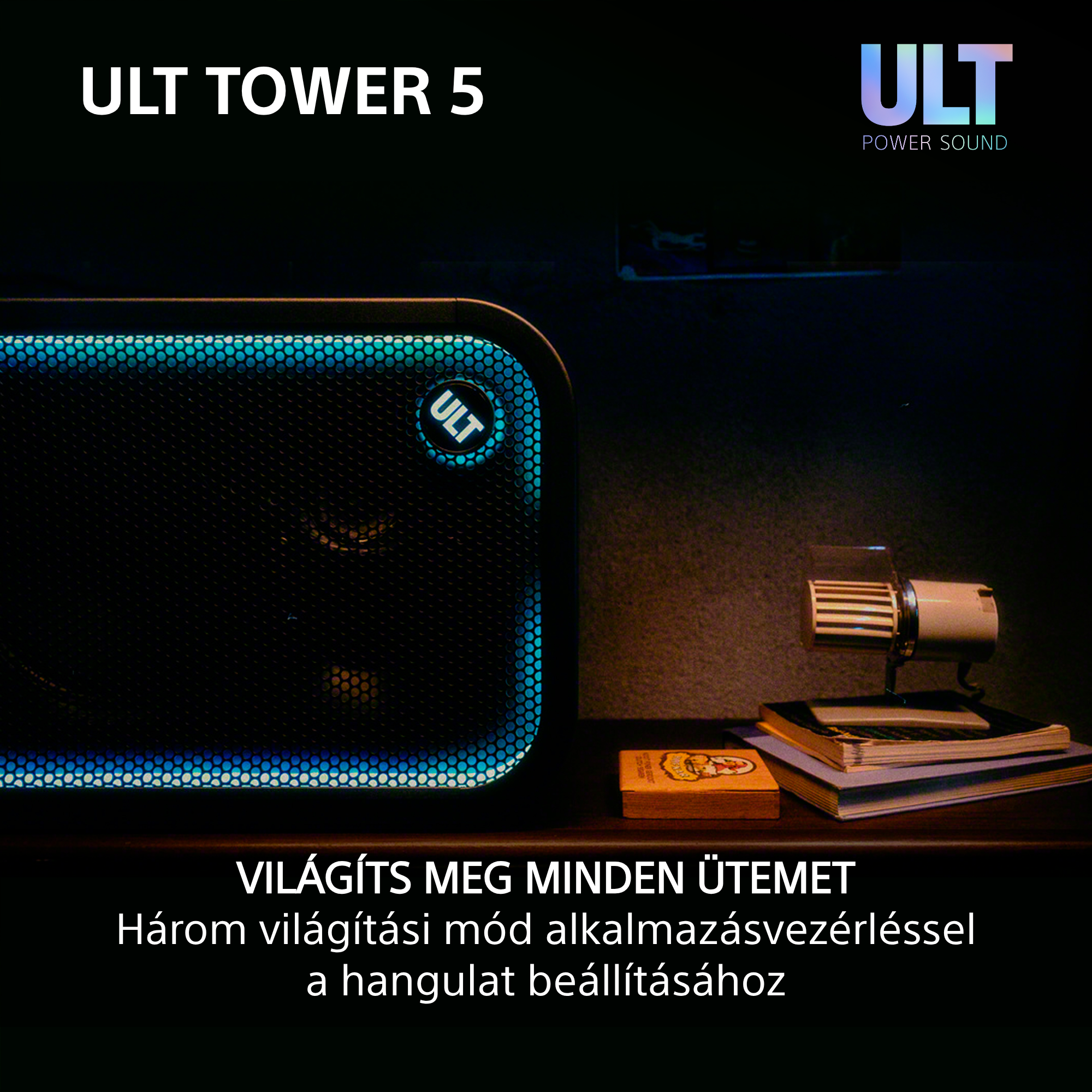 Egy fekete ULT Tower 5 hangszóró kék fényekkel világít egy sötét fa felületen.