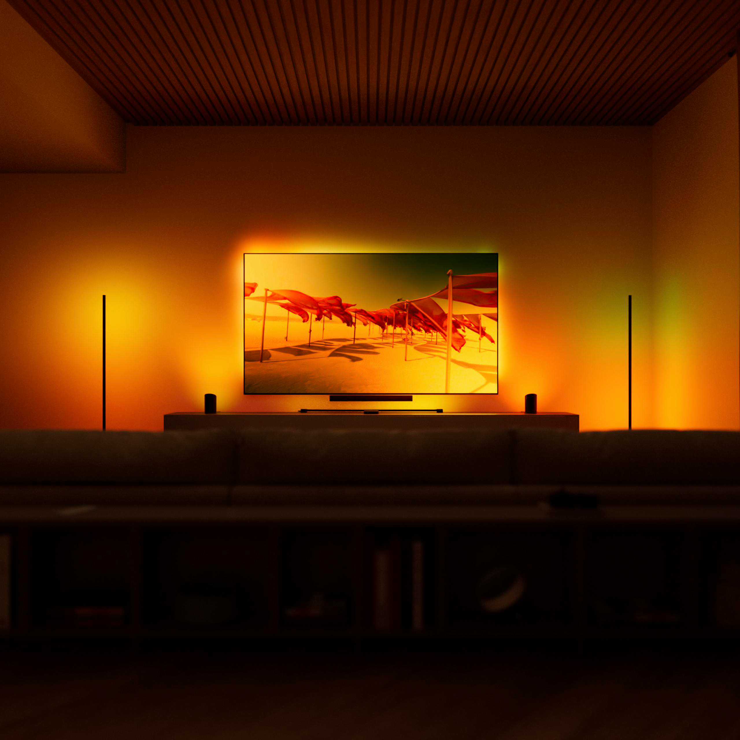 Wohnzimmer mit beleuchtetem Fernseher und roter Strandlandschaft auf dem Bildschirm.