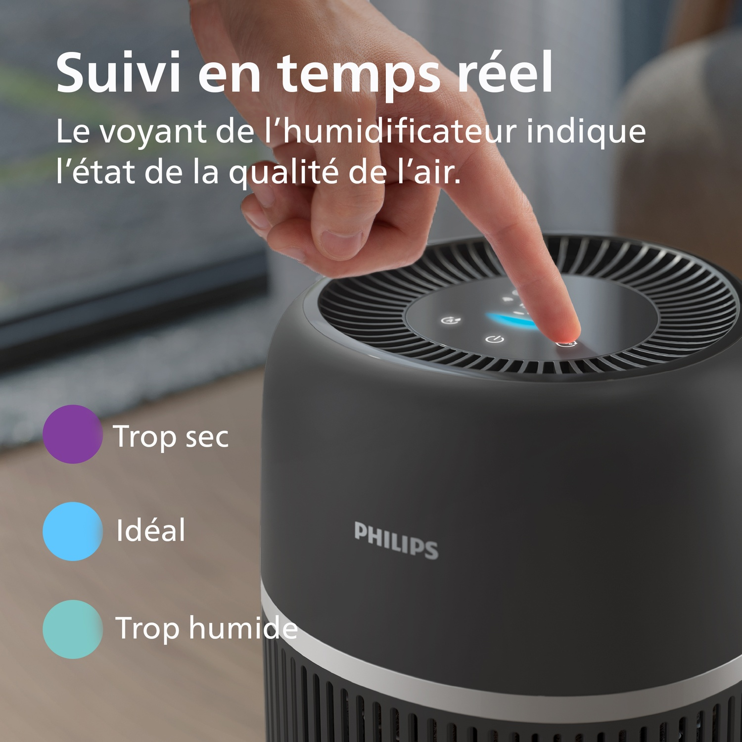 Une main touche le panneau de commande d'un humidificateur Philips noir. Texte indiquant l'état de la qualité de l'air.