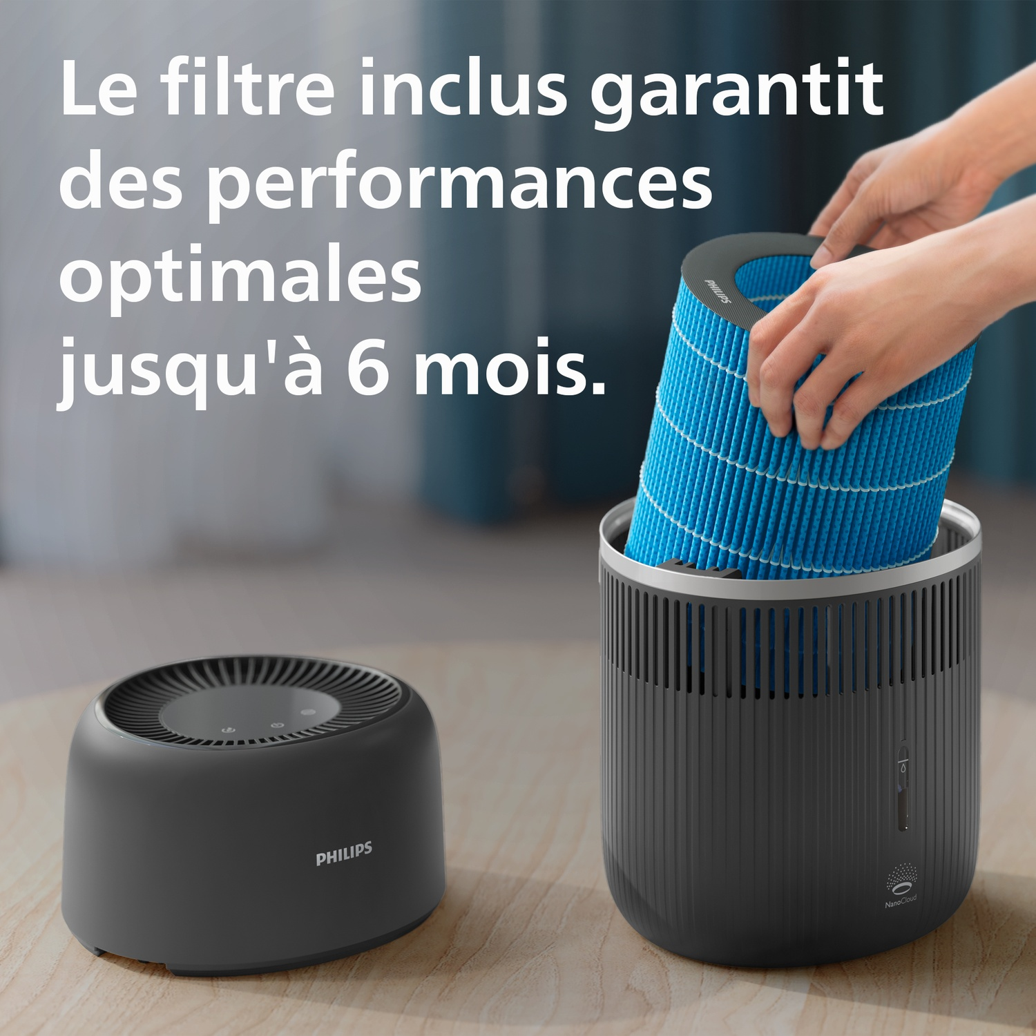 Mains insérant un filtre bleu dans un humidificateur Philips gris sur une table.