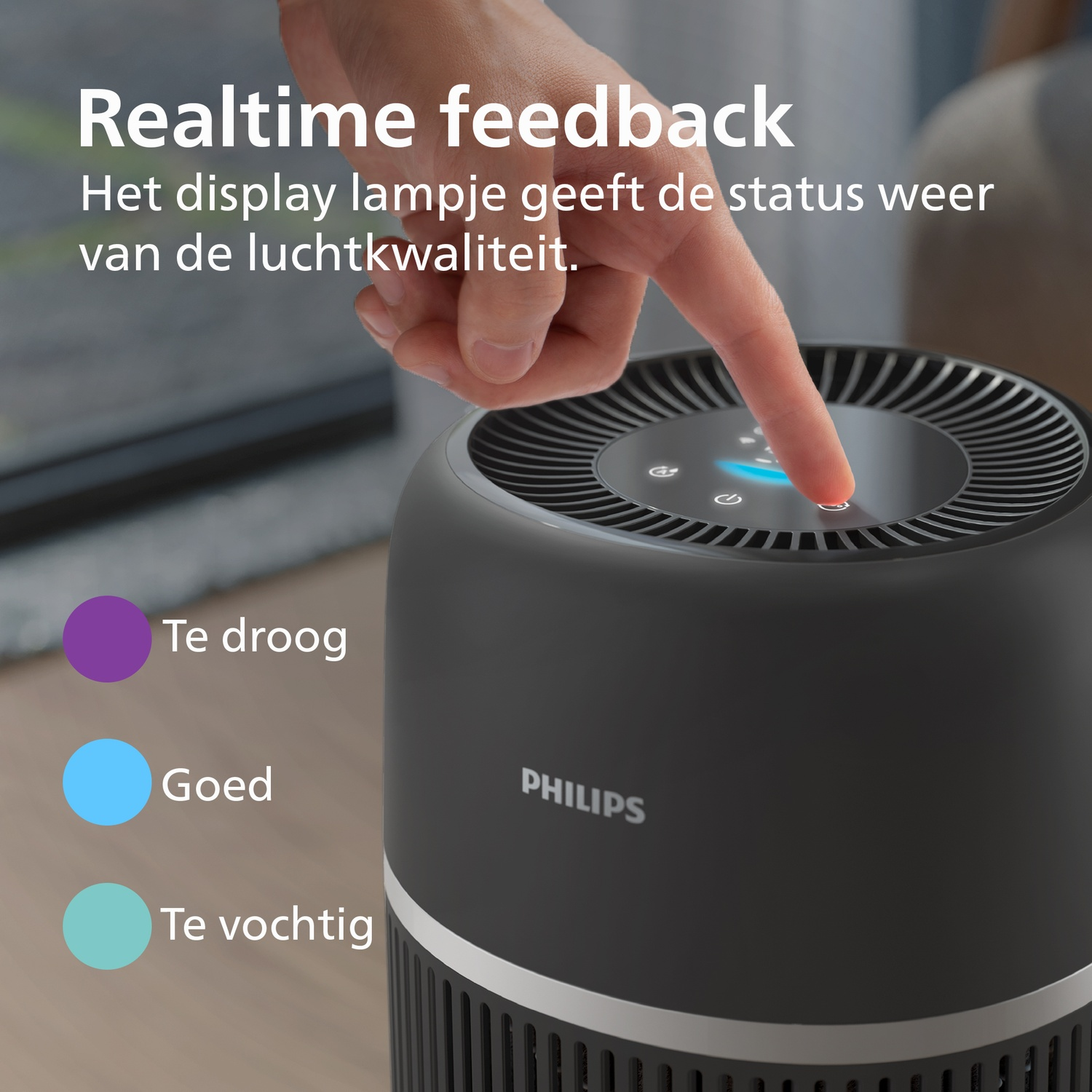 Hand raakt het bedieningspaneel aan van een Philips luchtreiniger met tekst en kleurindicatoren.
