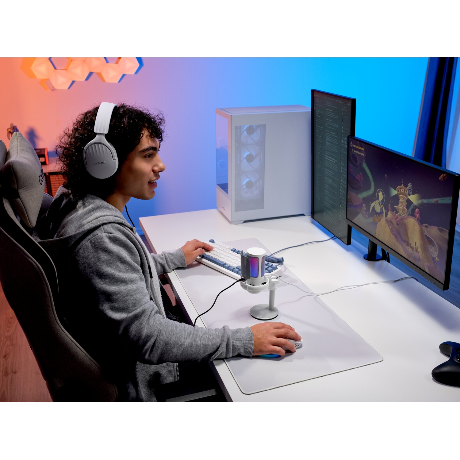 Un giovane con le cuffie siede a una scrivania giocando a un videogioco sul computer.