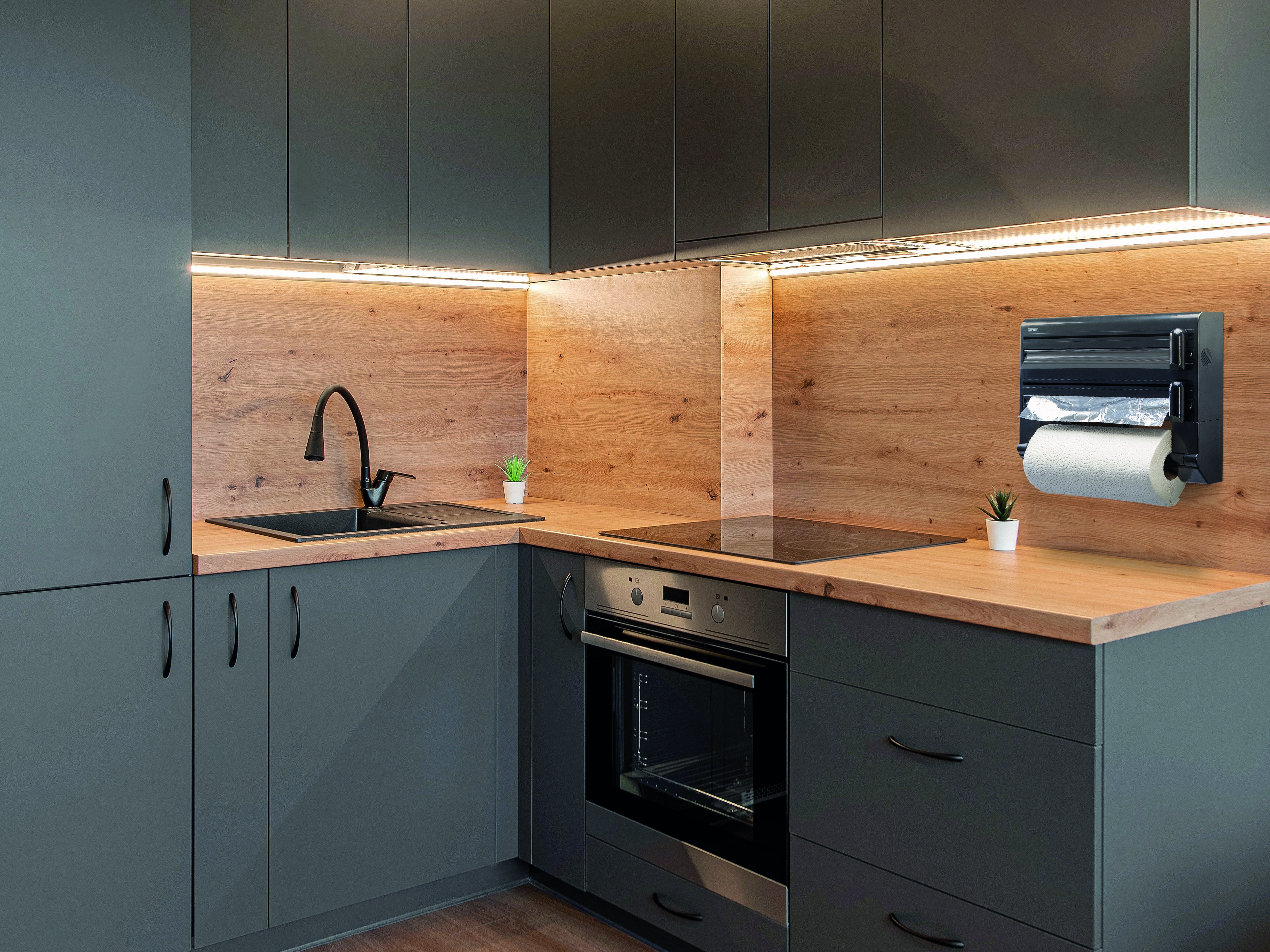 Moderne Küche mit grauen Schränken, Holzrückwand, schwarzem Waschbecken, Einbauherd und Küchenrollenhalter.