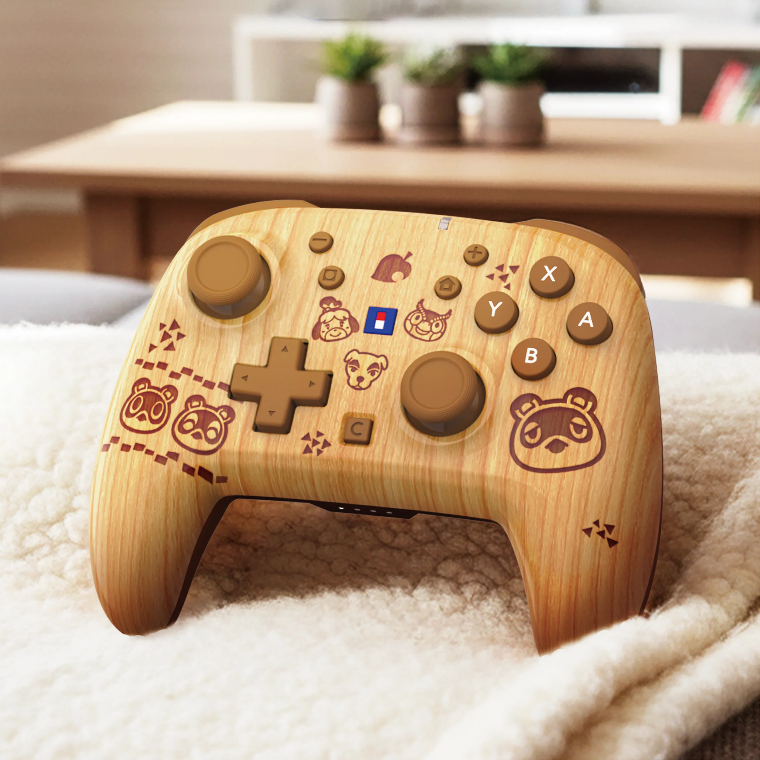 Ein kabelloser Holzcontroller im Animal Crossing-Design liegt auf einer flauschigen weißen Decke vor verschwommenem Hintergrund.