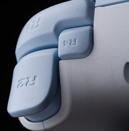 Nahaufnahme der R1-, R2- und R4-Tasten eines hellblauen und weißen Controllers auf schwarzem Hintergrund.