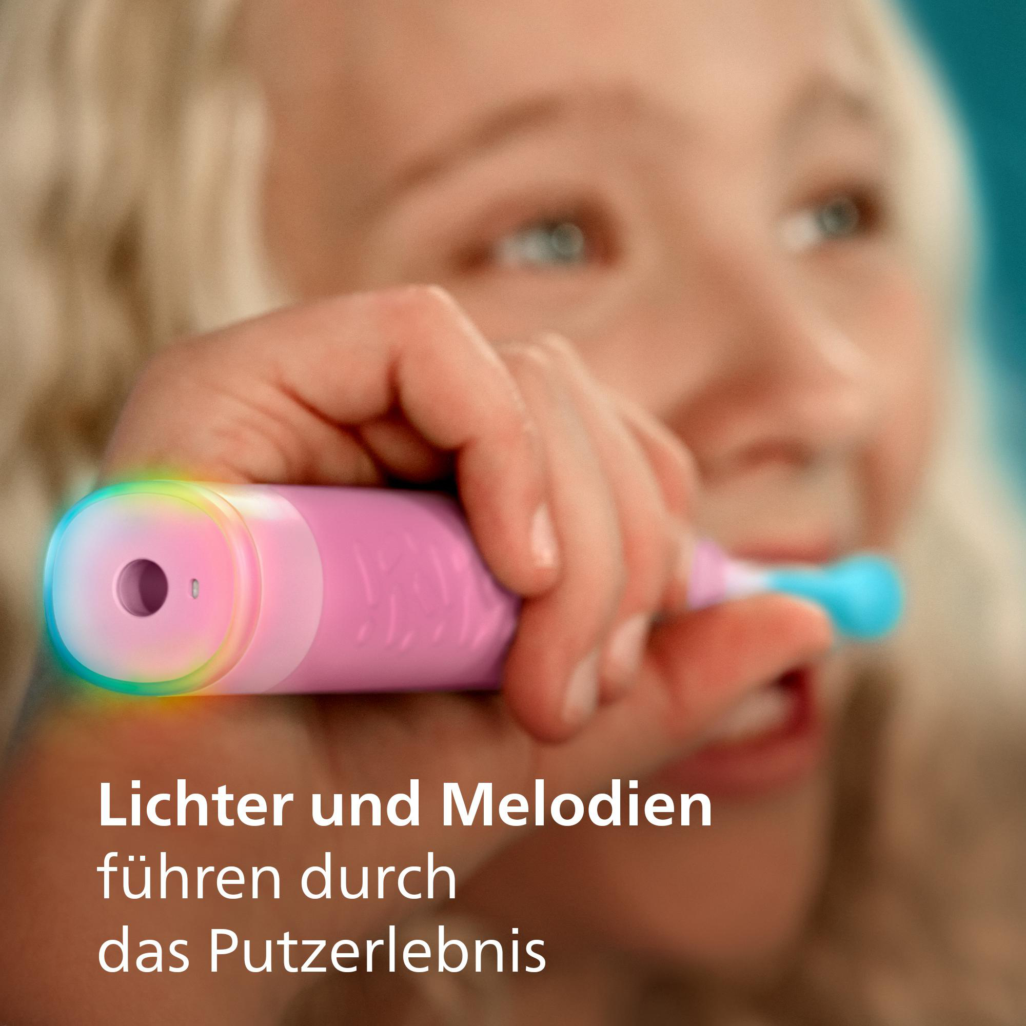 Ein junges Mädchen lächelt beim Zähneputzen mit einer rosa elektrischen Zahnbürste, die bunt leuchtet.