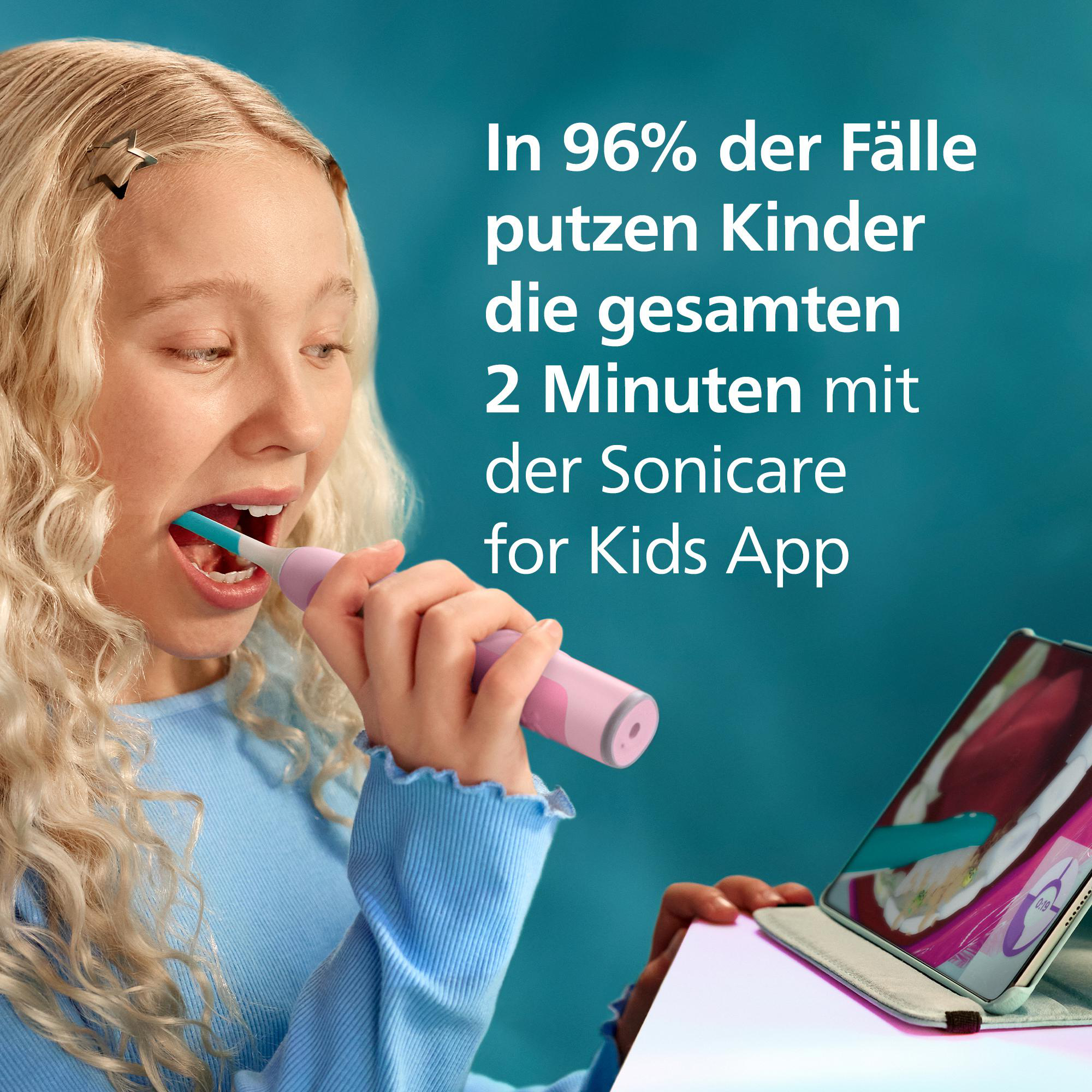 Ein blondes Mädchen putzt sich mit einer Sonicare Kinderzahnbürste die Zähne und schaut auf ein Tablet.
