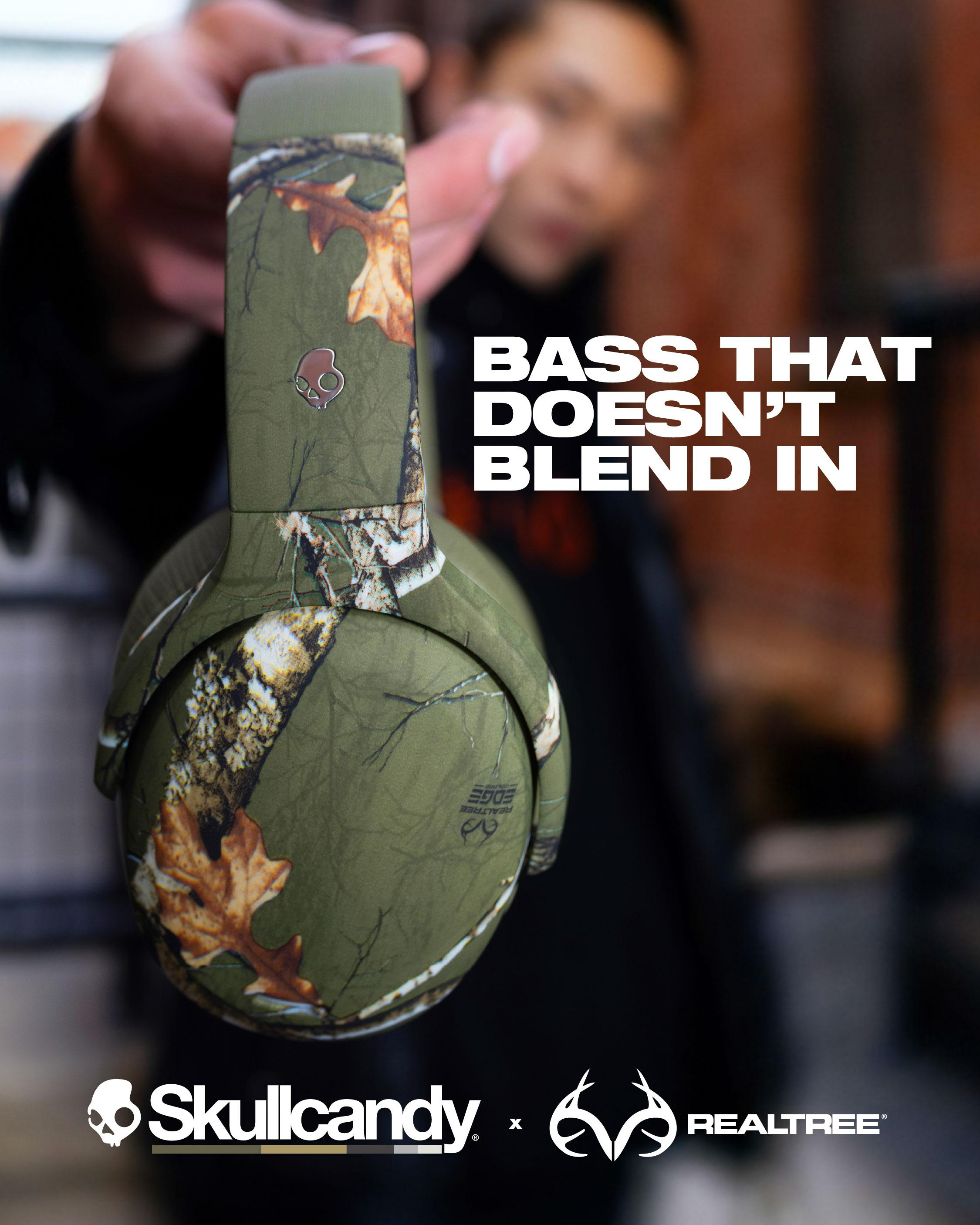 Person hält Realtree-Camo-Kopfhörer vor die Kamera; Text: BASS THAT DOESN'T BLEND IN.