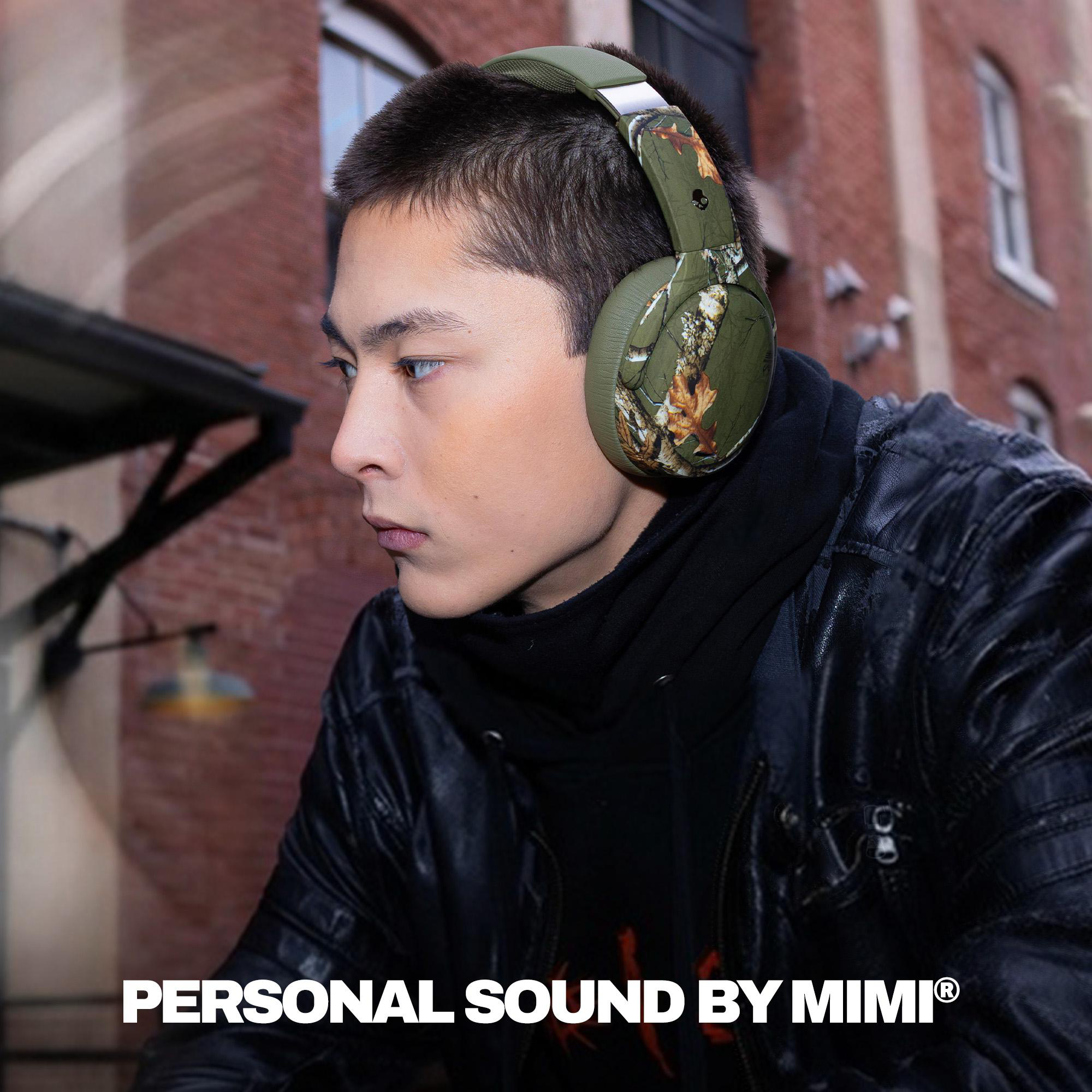 Junger Mann trägt Camouflage-Kopfhörer und schwarze Jacke draußen, mit dem Text PERSONAL SOUND BY MIMI unten.