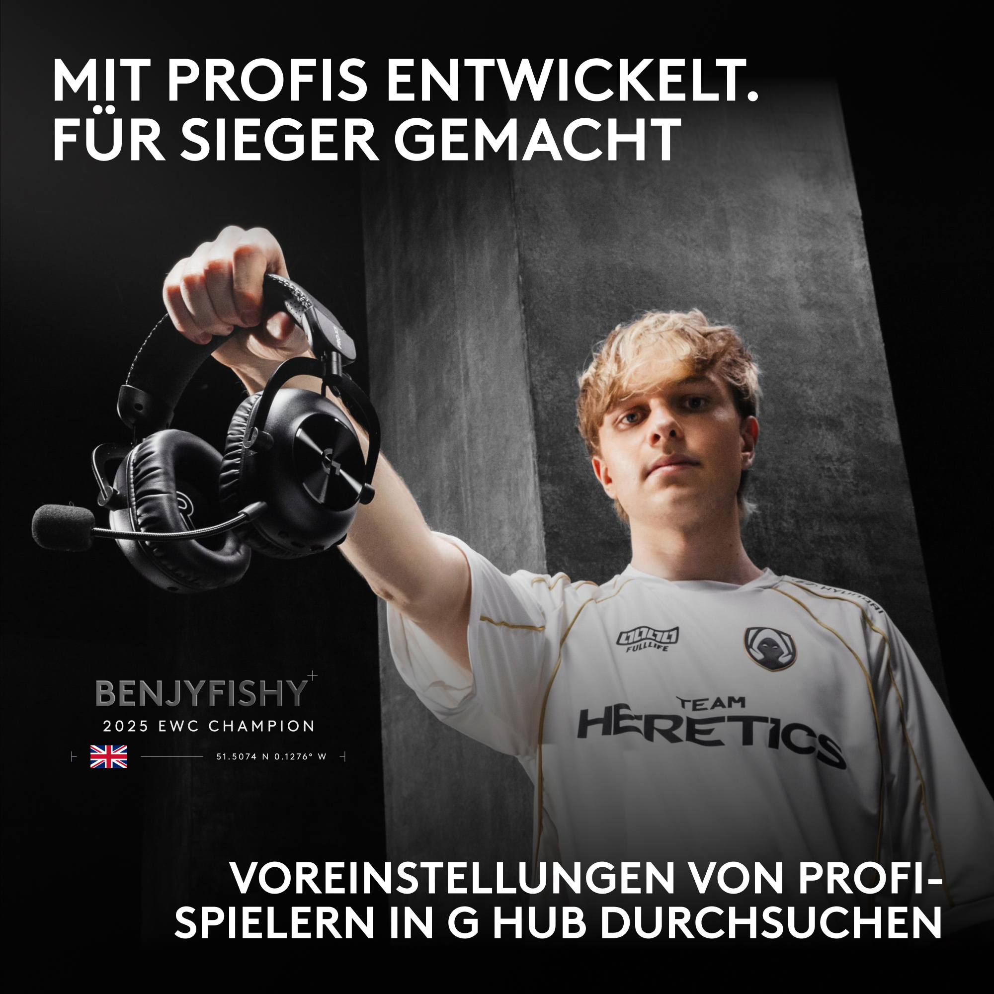 Ein blondes Team-Mitglied von Team Heretics hält einen schwarzen Gaming-Kopfhörer vor dunklem Hintergrund.