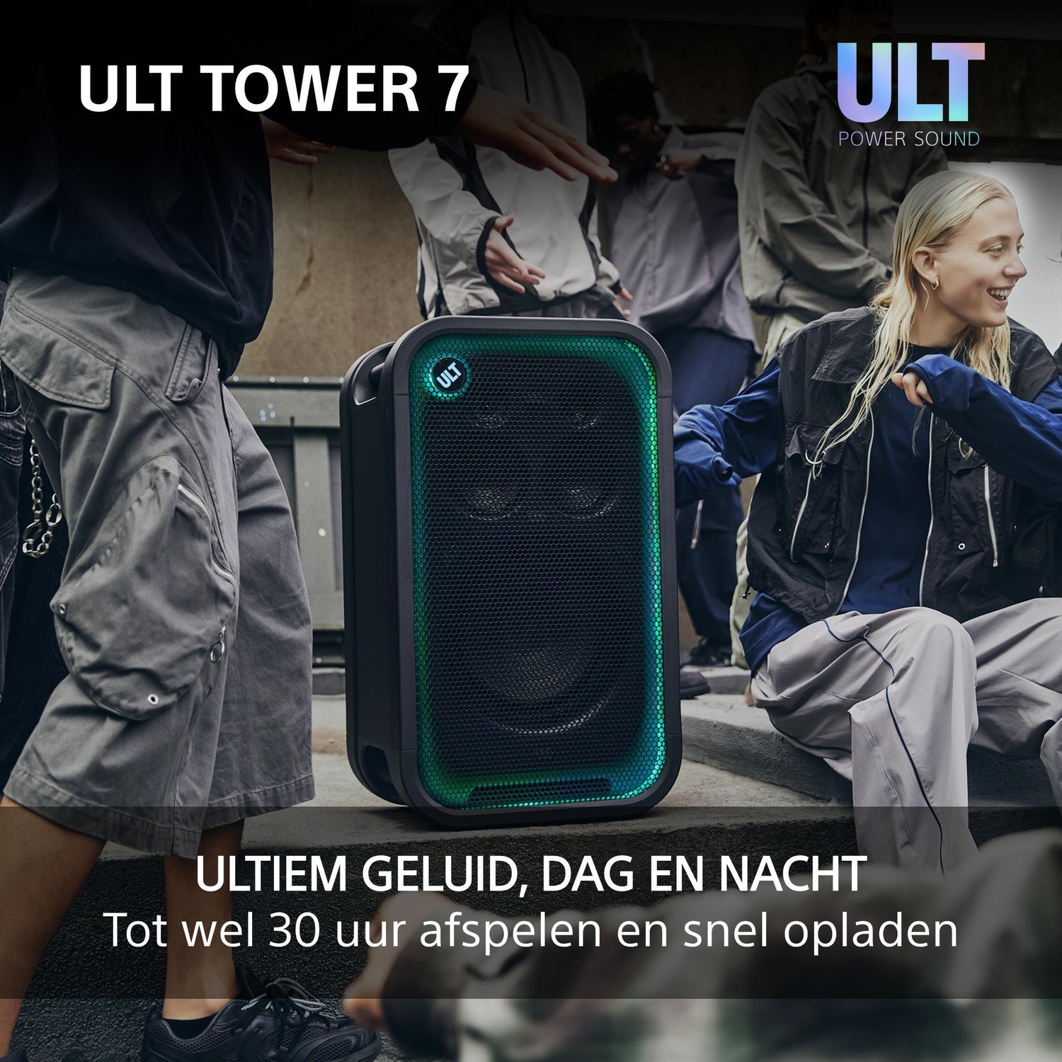 Een ULT Tower 7-speaker gloeit groen terwijl jongeren buiten dansen.