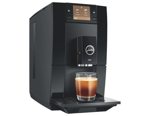 Eine schwarze Jura Kaffeemaschine steht auf einer Fläche mit einer Kaffeetasse davor.